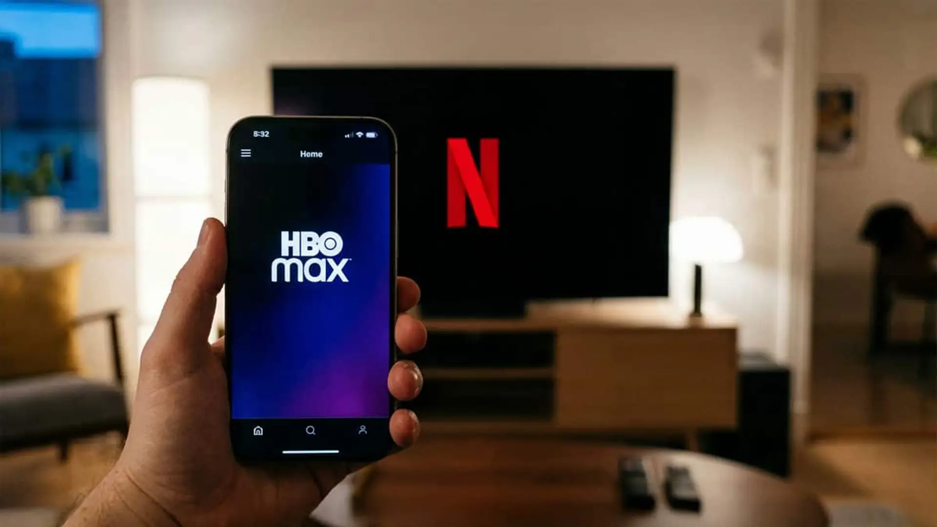 ¿Tienes suscripción a HBO Max? Esto es lo que pasará (de momento) si la compra Netflix Usuario sostiene un móvil con la app de HBO Max abierta mientras Netflix aparece en la televisión del salón.