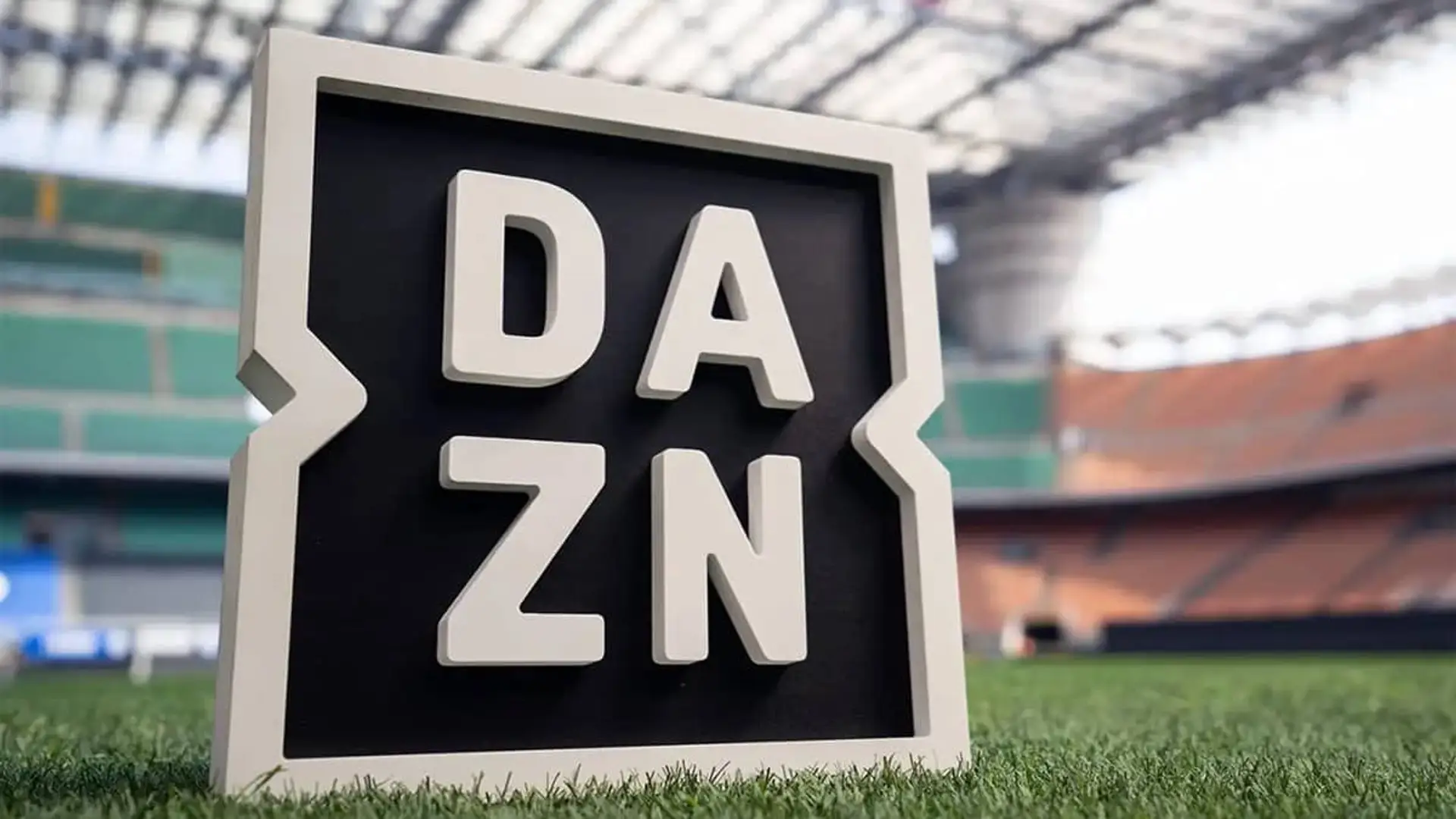 Logo de la plataforma de streaming DAZN sobre el césped de un estadio de fútbol, simbolizando su cobertura de deportes.