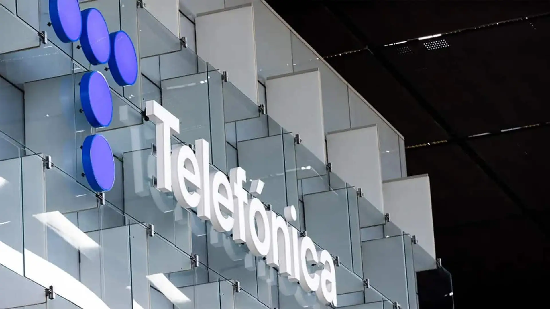 De centrales de cobre a data centers: el plan de Telefónica para fulminar la latencia en la era de la IA Detalle del logotipo de Telefónica sobre fachada acristalada en edificio corporativo.