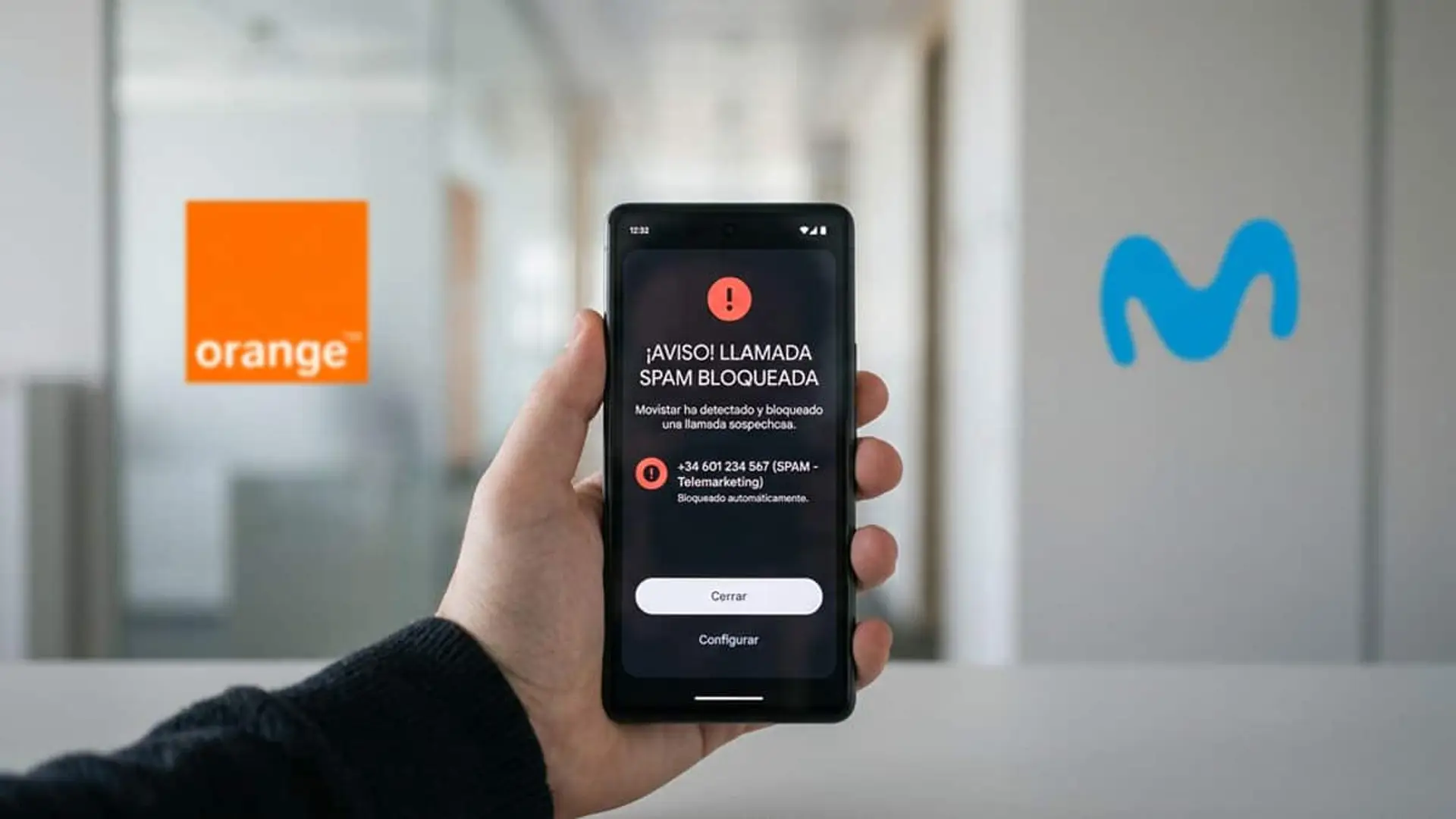 Móvil con un aviso de llamada spam bloqueada y los logotipos de Orange y Movistar al fondo
