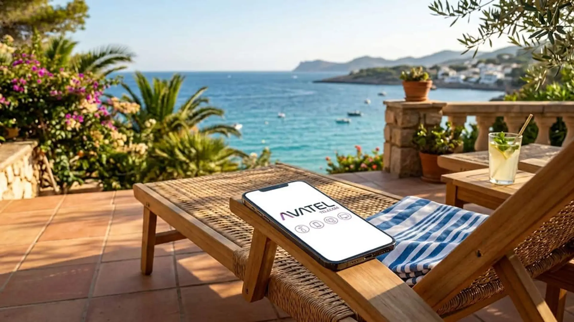 Móvil con el logotipo de Avatel sobre una tumbona en una terraza con vistas al mar