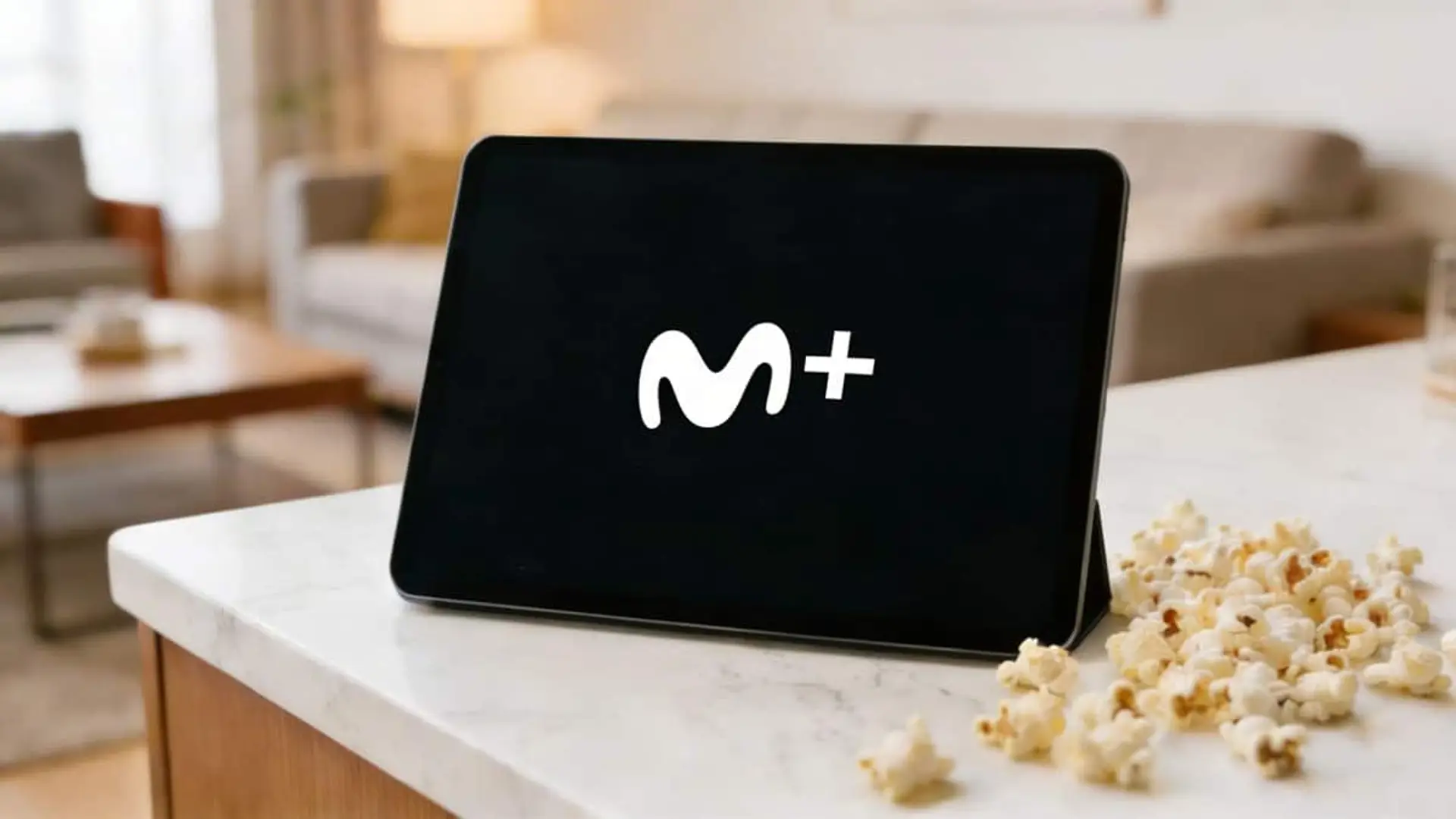 Movistar Plus+ lanza Freemium, el canal con el que quiere que te enganches a sus series Tablet con el logo de Movistar Plus junto a palomitas en un salón, representando el consumo de contenido en streaming en casa.