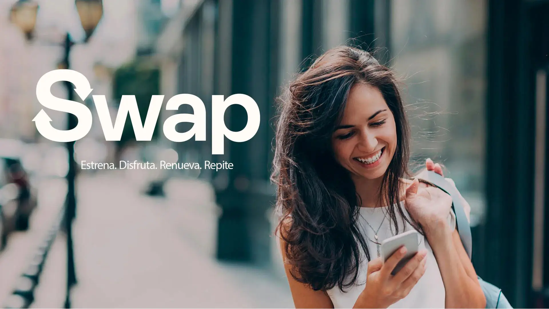 Mujer sonriente usando su móvil gracias al programa Swap, un servicio de renting para estrenar y renovar tecnología fácilmente.