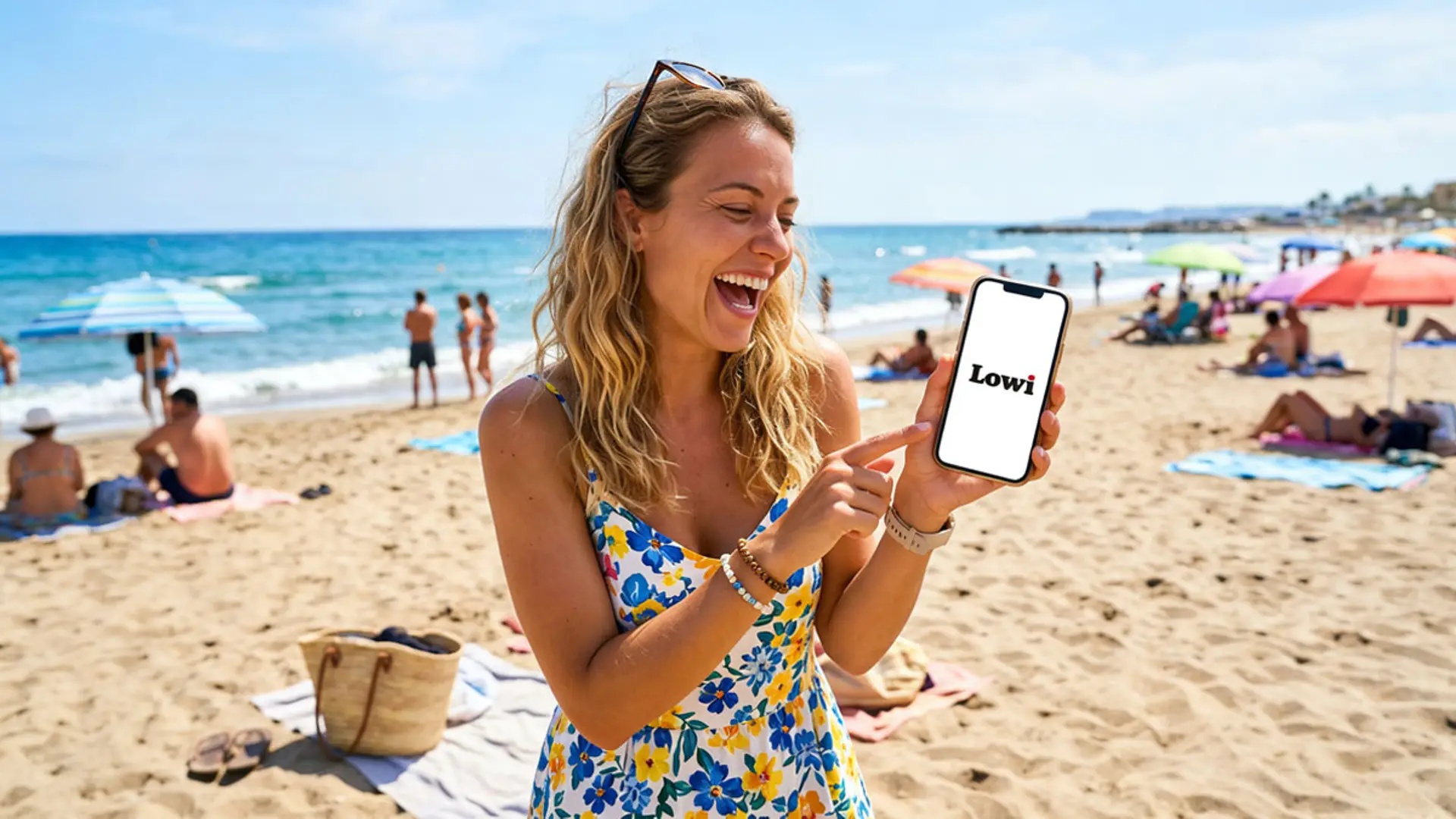 Mujer sonriendo en la playa mientras muestra en el móvil la app de Lowi