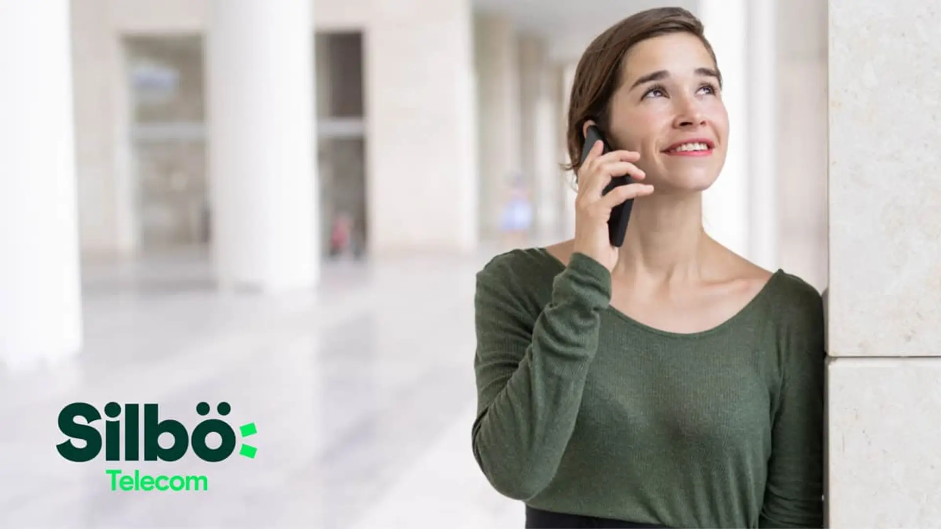 Mujer hablando por teléfono móvil junto al logotipo de Silbö Telecom para servicios de fibra y telefonía.