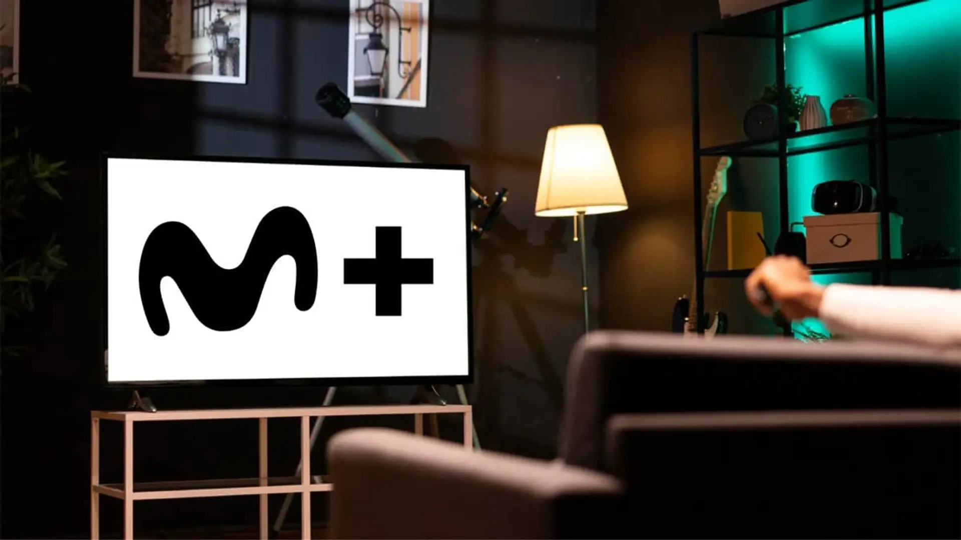Logotipo de M+ en una Smart TV mientras un usuario utiliza el mando a distancia en su salón.
