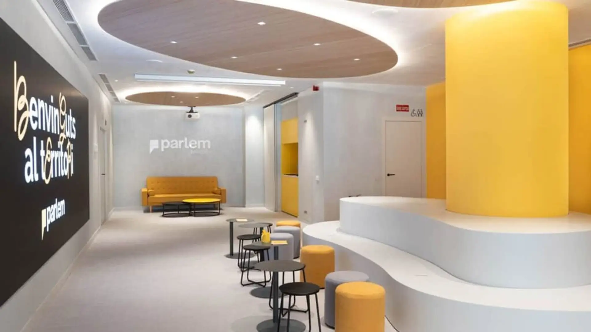 Oficina moderna de Parlem Telecom con diseño corporativo en amarillo y blanco y zonas de trabajo colaborativo.