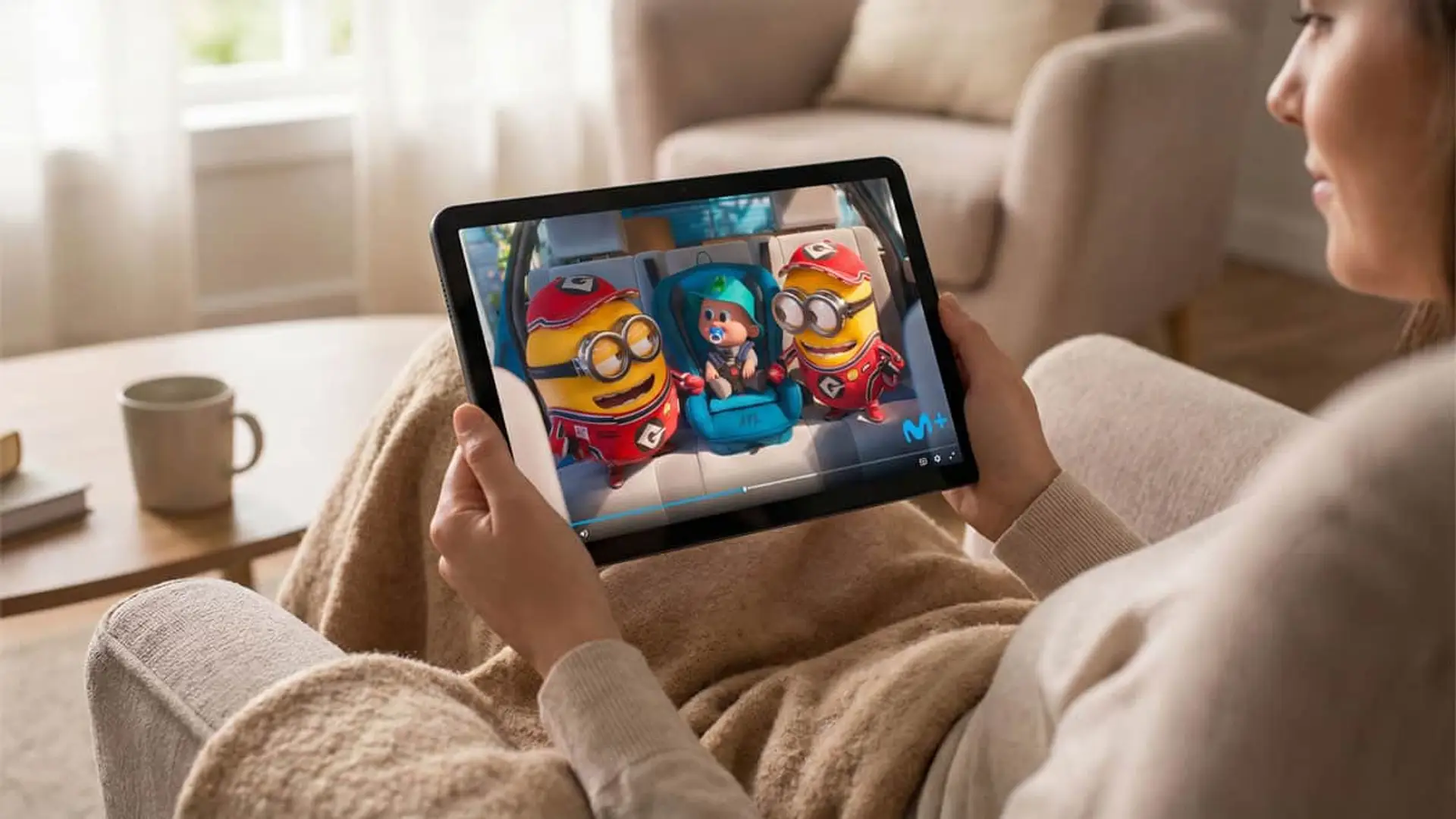 Mujer viendo película infantil de Gru 4 en la app de Movistar Plus+ desde una tablet.