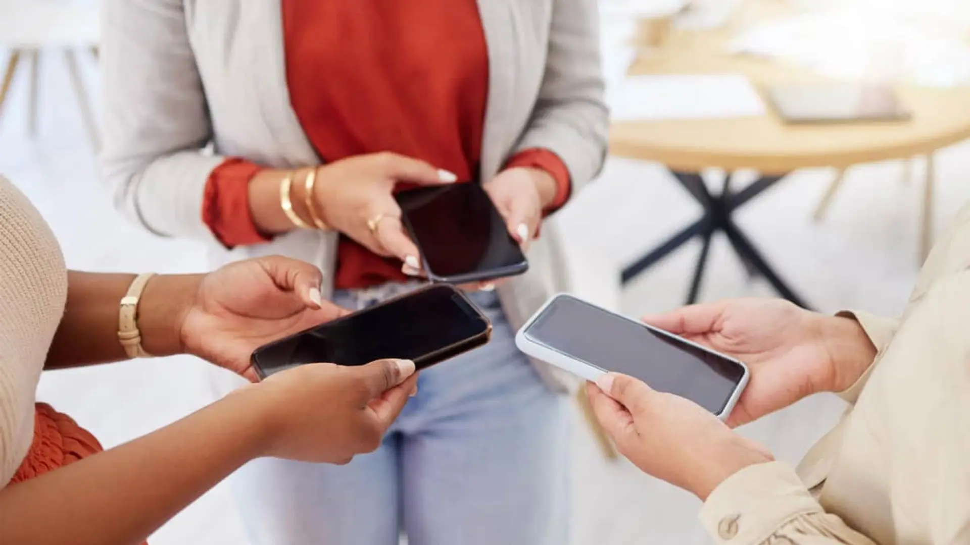 DIGI y Telefónica: la guerra por las portabilidades tiene dos ganadores claros en lo que va de año Tres personas usando sus smartphones con conectividad de diferentes compañías.