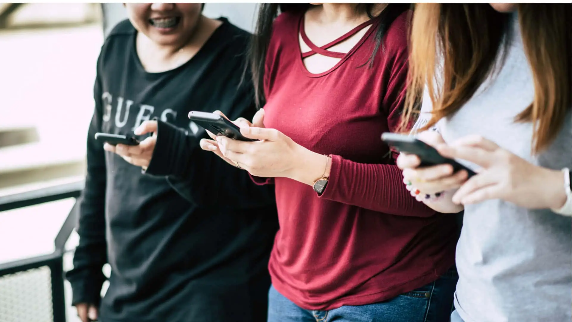 Grupo de amigas jóvenes conectadas a sus móviles, navegando en redes sociales. Símbolo de la comunicación en la era digital.