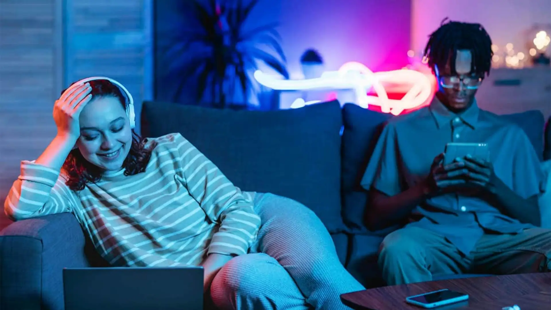 Estas son las 3 operadoras que te ofrecen fibra, dos líneas y TV desde 20€ al mes Pareja joven disfrutando del entretenimiento digital en casa: ella ve una serie en el portátil y él usa una tablet.