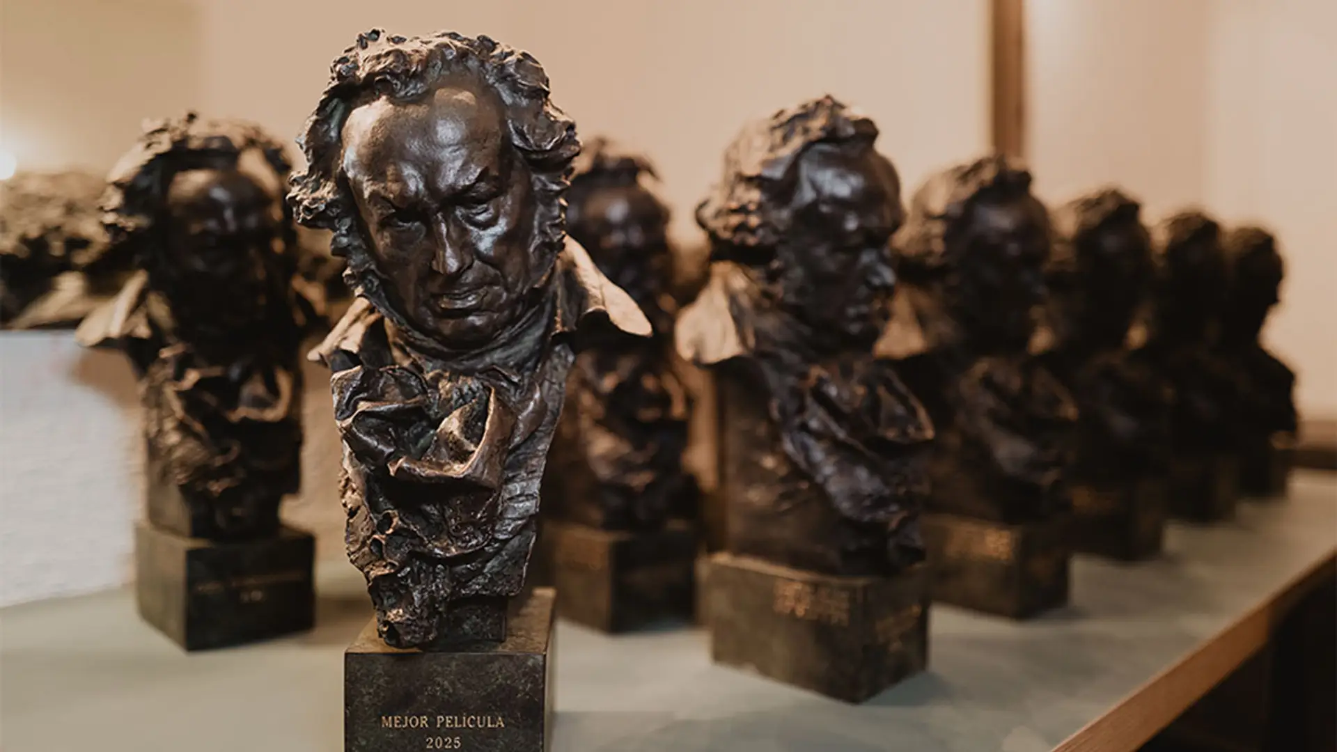 Dónde ver las películas nominadas a los Goya 2026: Los Domingos, Sirat y más en plataformas de streaming Varias estatuillas de los Premios Goya en una mesa.