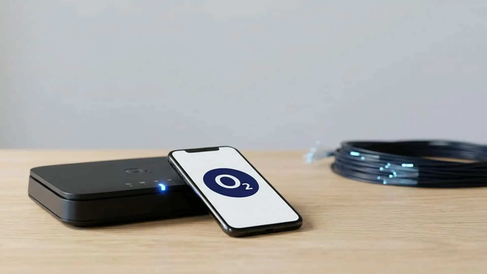 Por qué O2 tardará en tener fibra de 10 Gbps aunque comparte red con Movistar Router y móvil con el logotipo de O2 sobre una mesa de madera