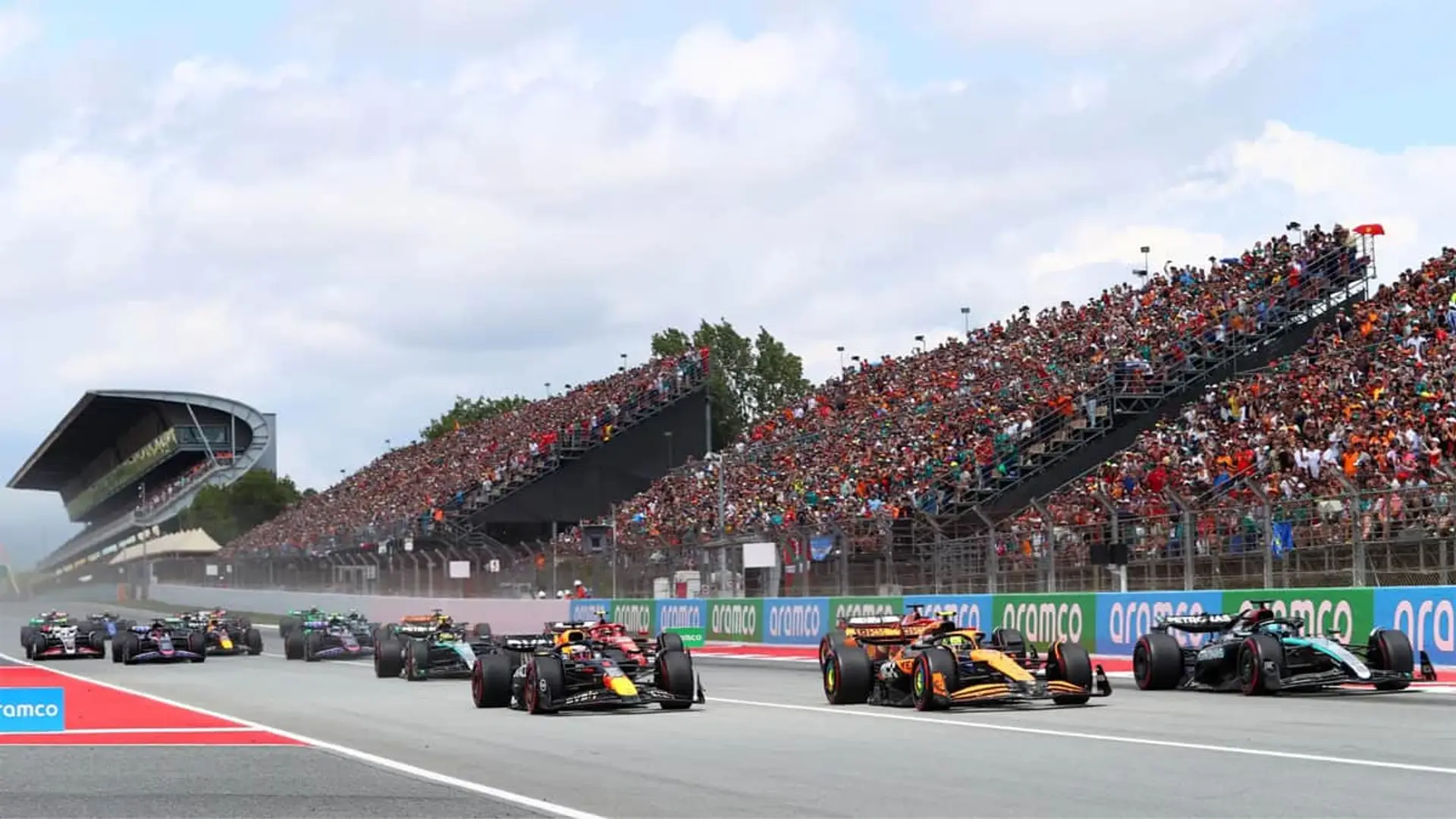 Salida del Gran Premio de España de Fórmula 1 con monoplazas compitiendo ante miles de aficionados