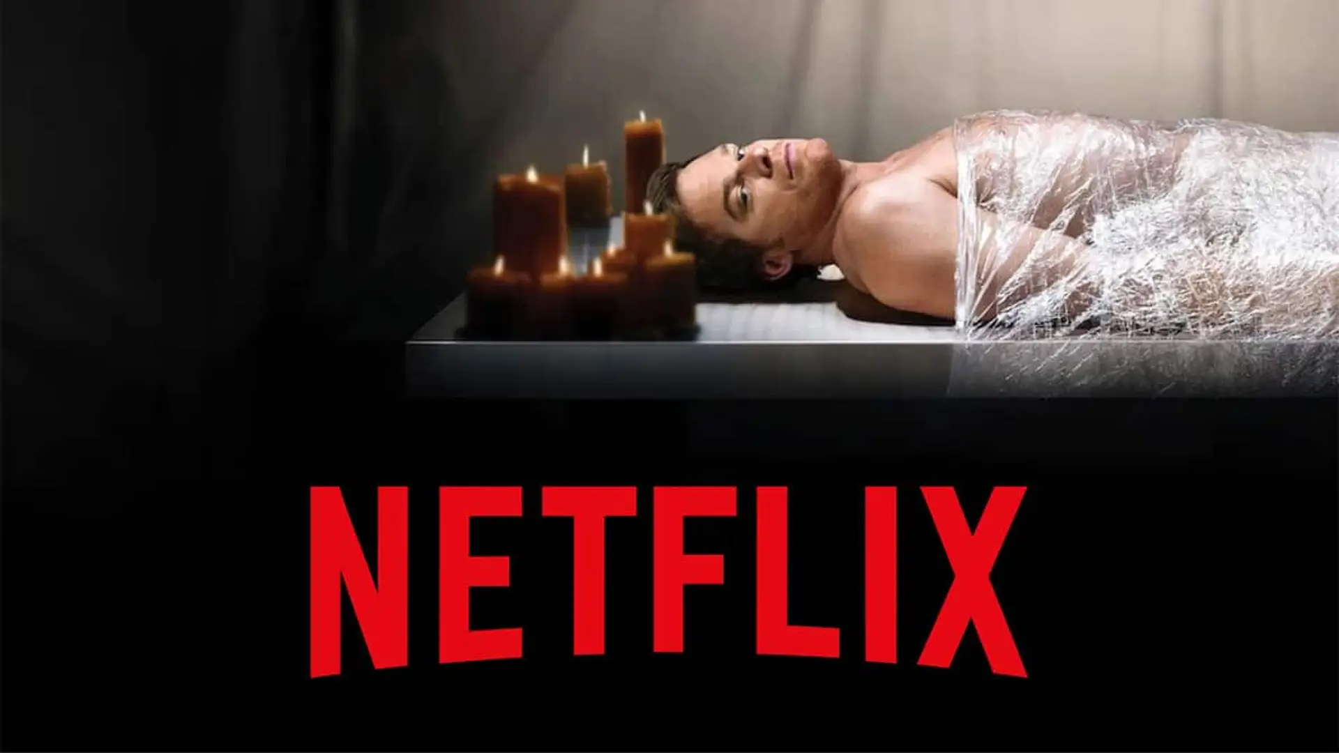 Escena de Dexter, con el protagonista en una mesa rodeado de velas en una atmósfera oscura y el logo de Netlix en la parte inferior.