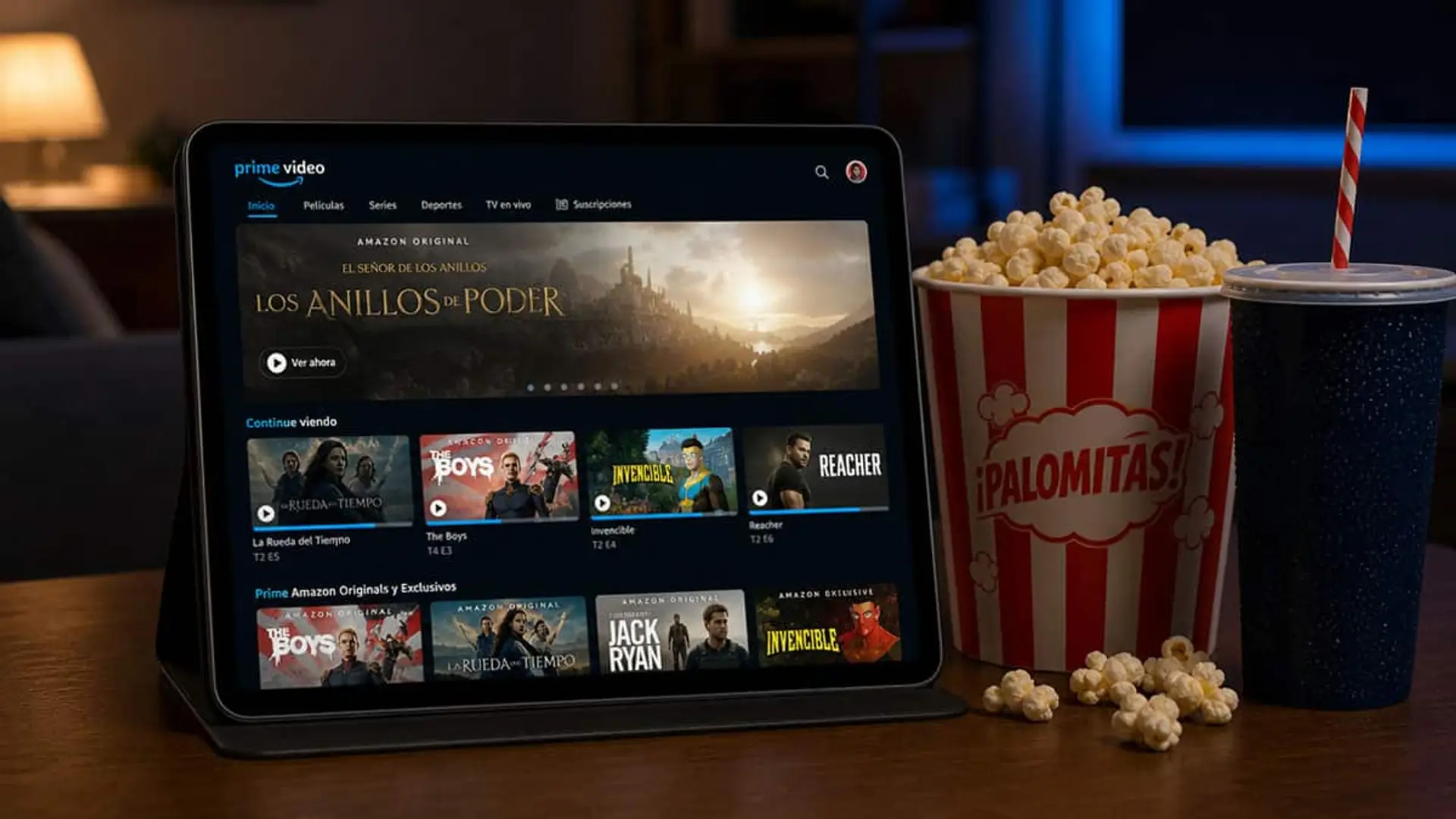 Tablet con Prime Video en pantalla junto a un cubo de palomitas y un refresco sobre una mesa
