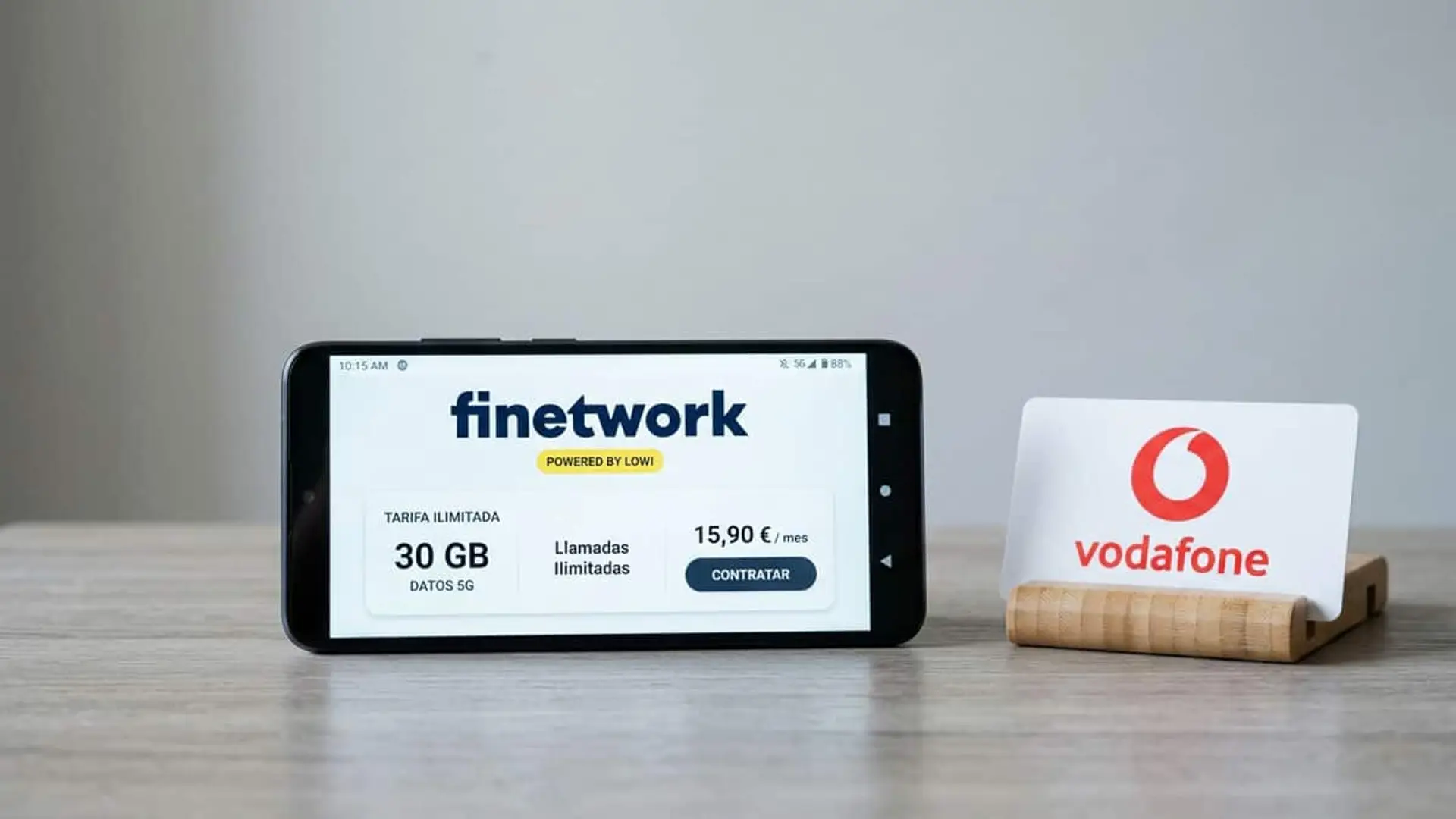 Teléfono móvil con una tarifa de Finetwork de 30 GB y llamadas ilimitadas junto al logotipo de Vodafone