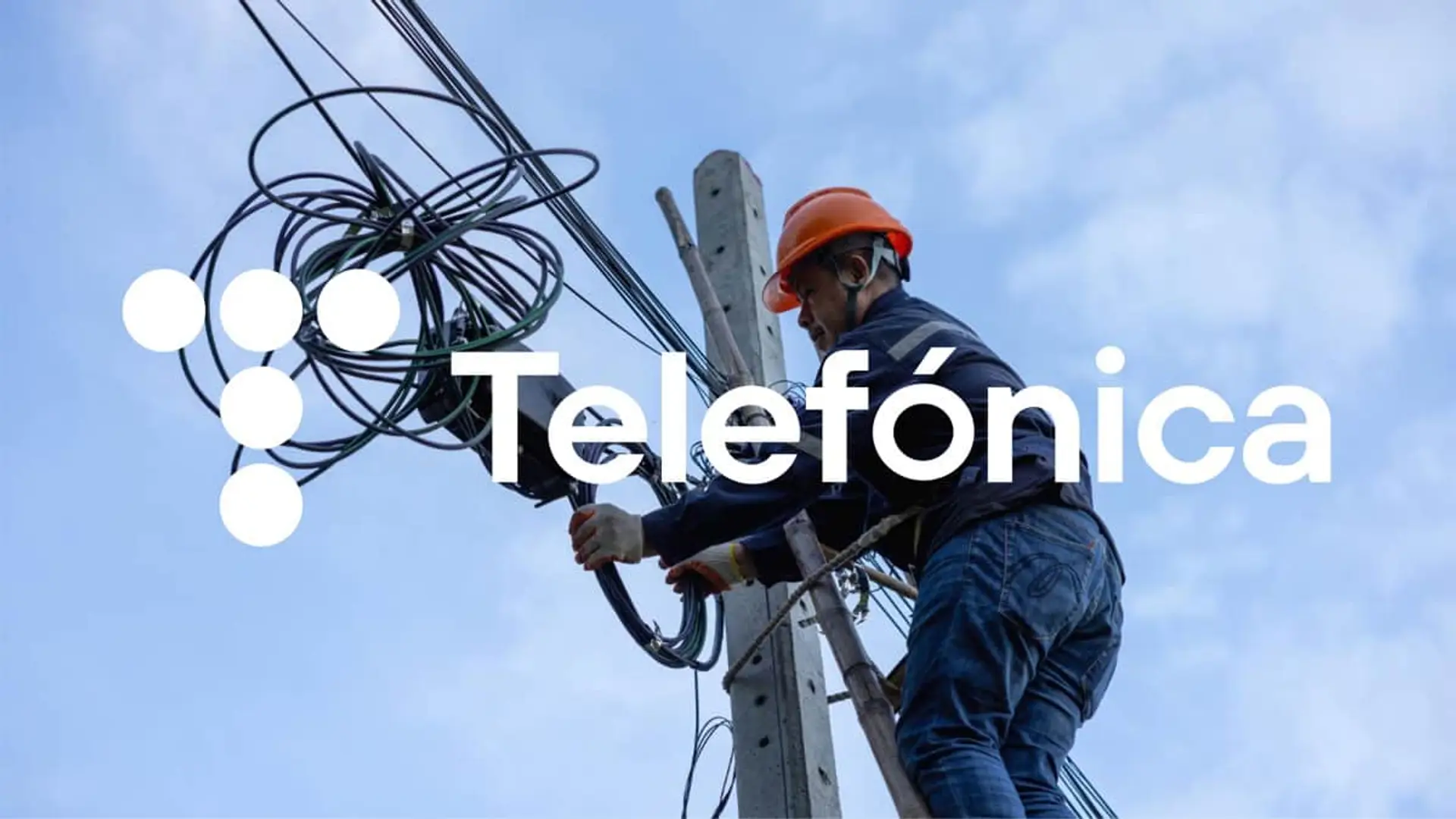 Técnico de Telefónica realizando el mantenimiento de cables en un poste para mejorar la red de fibra óptica.