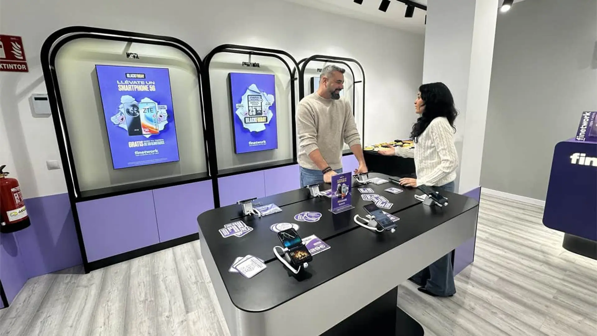 Interior de una tienda Finetwork con atención personalizada y pantallas con ofertas de smartphones y tarifas.
