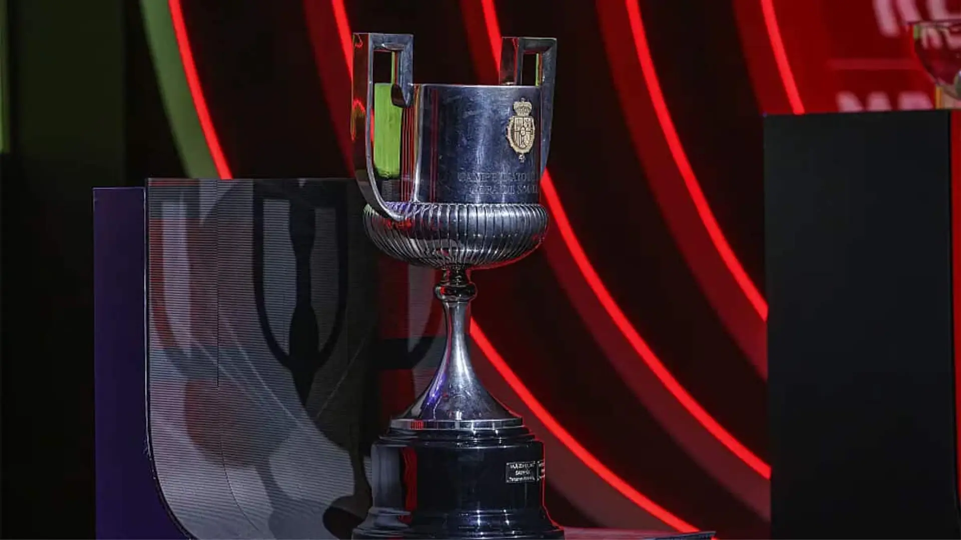 Trofeo de la Copa del Rey expuesto sobre un pedestal con iluminación roja durante la presentación oficial del torneo.