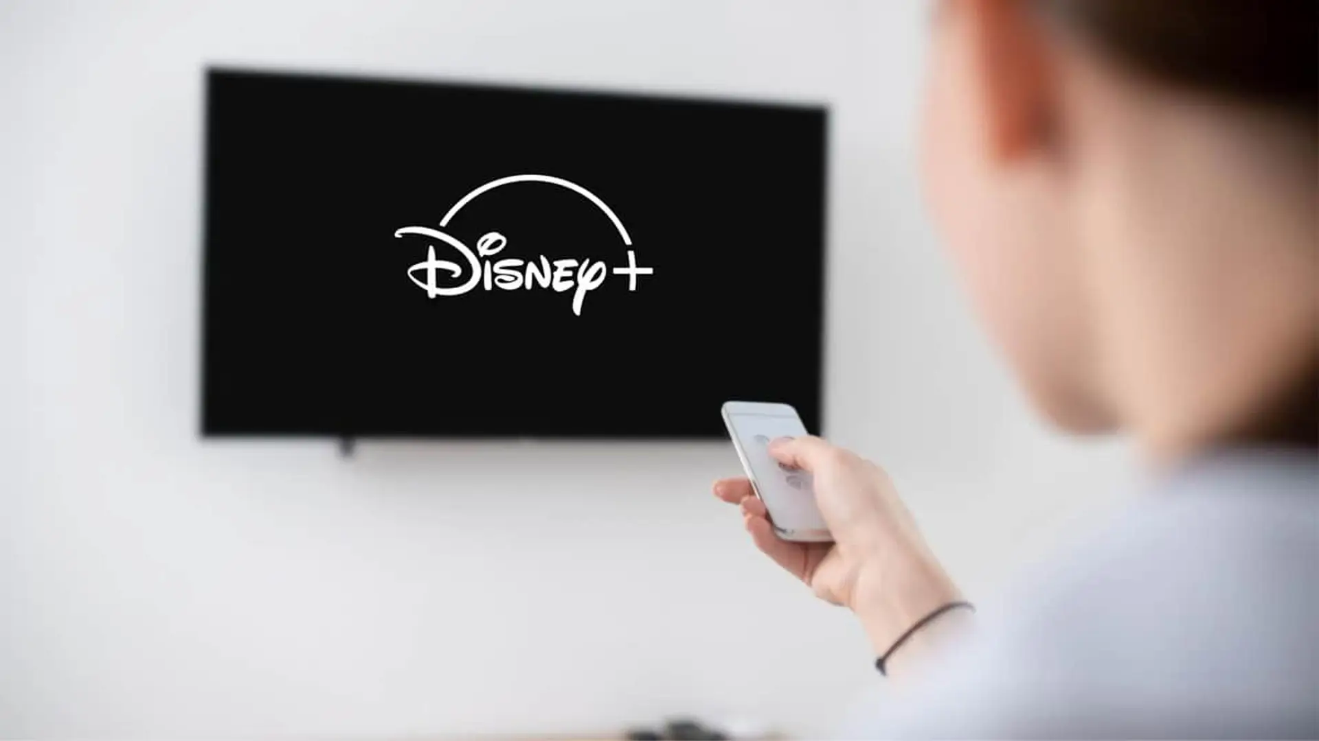 Usuario abriendo la app de Disney+ en su Smart TV para ver series y películas.