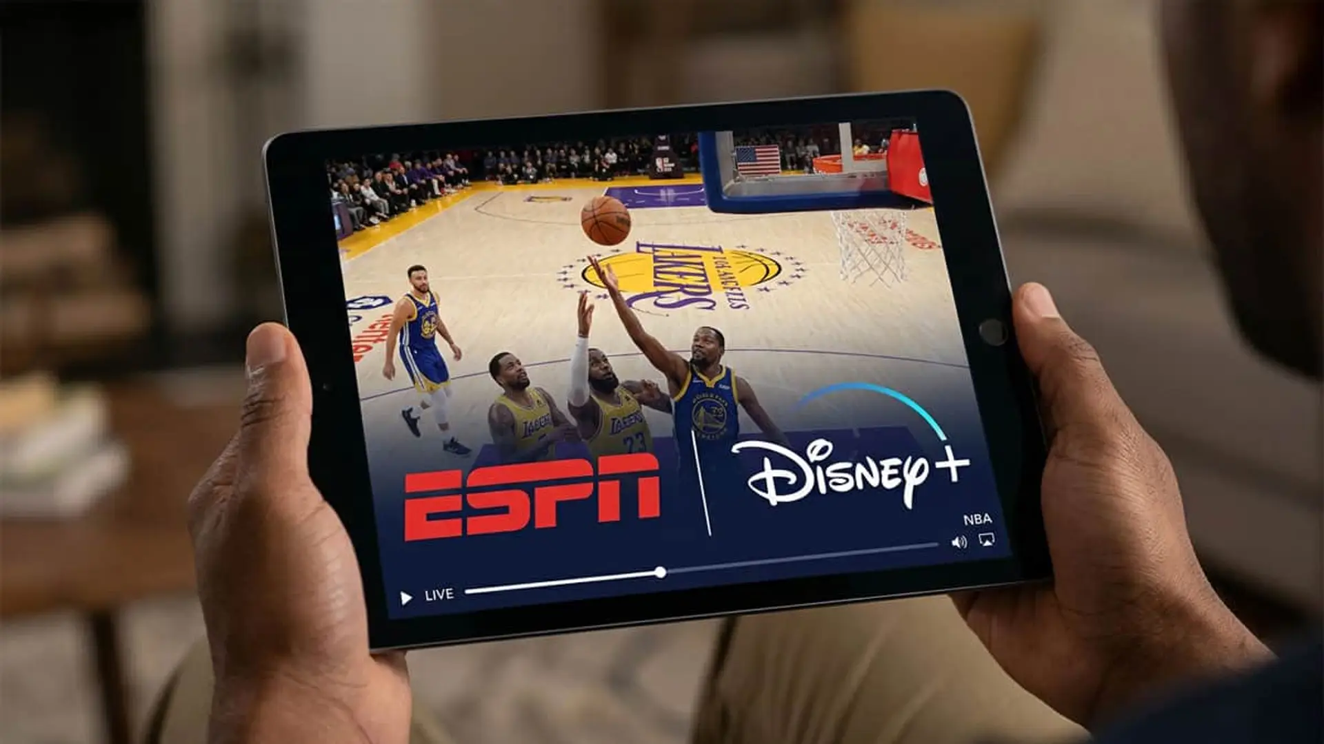 Mano sosteniendo una tablet para ver un partido de la NBA en ESPN a través de Disney+.