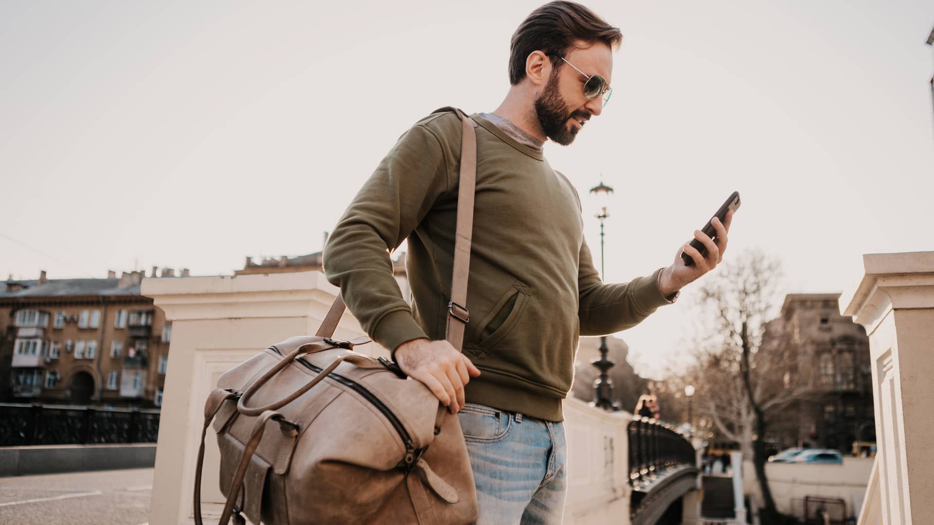 Hombre consulta en su móvil las tarifas de roaming de alterna a su llegada a otro país