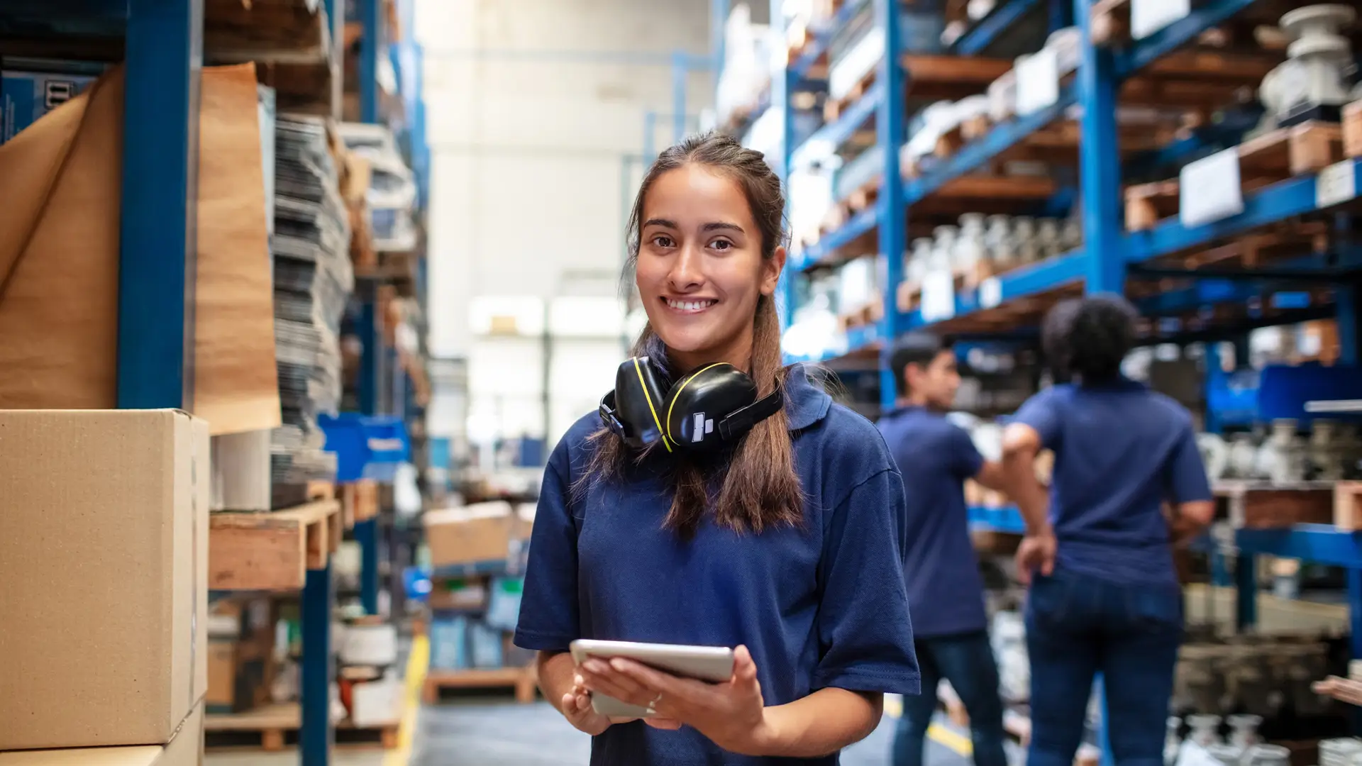 Trabajadora sonriente con tablet en almacen simboliza fibra empresas Trabajadora sonriente con tablet en almacen simboliza fibra empresas