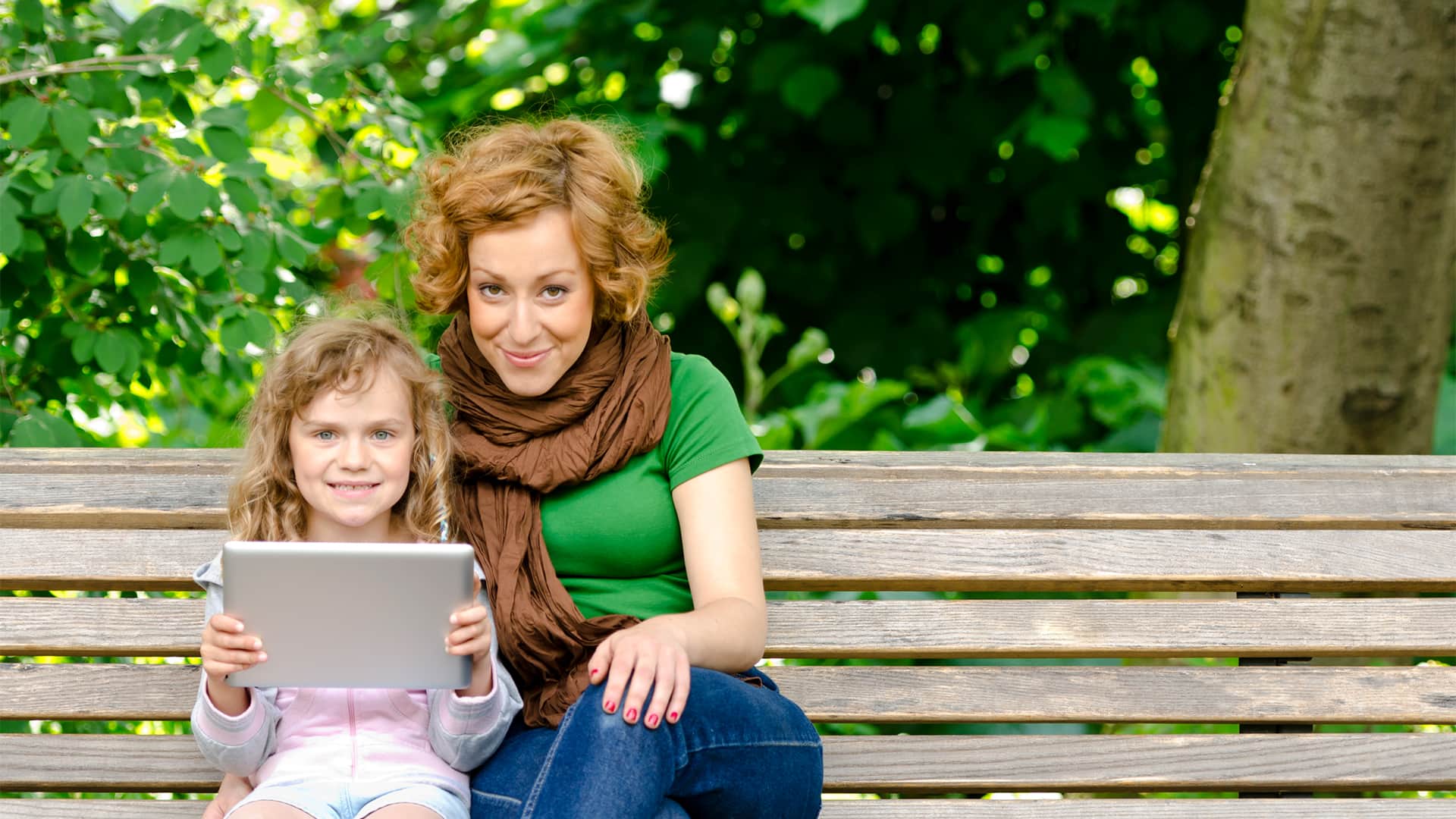 Madre e hija navegando en tablet en plena naturaleza con internet wimax