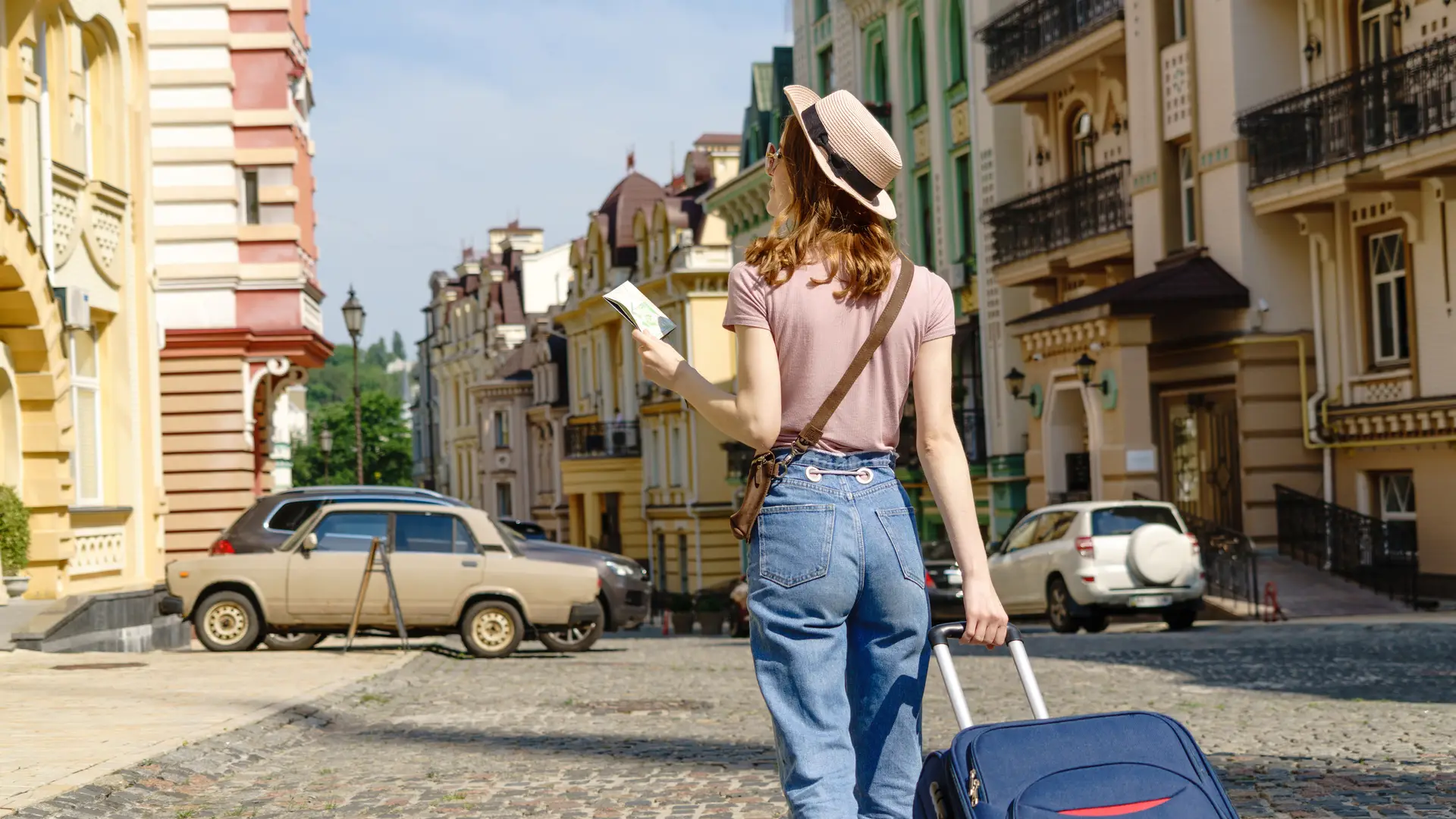 Mujer joven turista con maleta y mapa simboliza roaming unión europea Mujer joven turista con maleta y mapa simboliza roaming unión europea