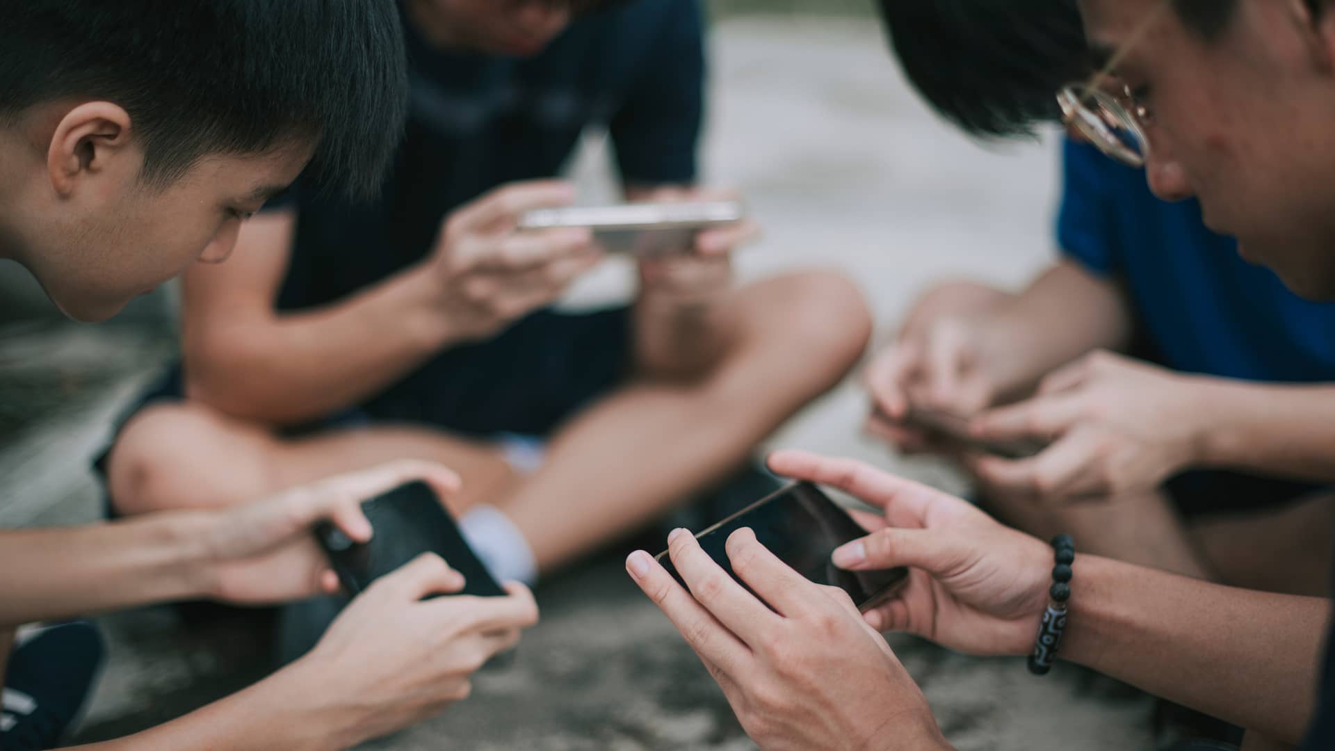 Jovenes jugando con los teléfonos móviles usando la tarifa solo datos