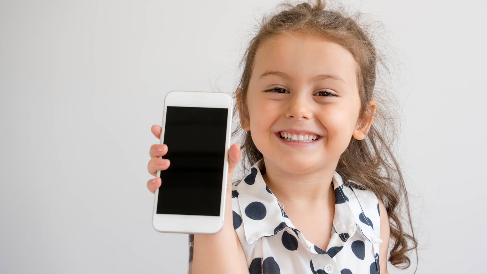 Niña jugando con smartphone simboliza tarifa móviles para niños