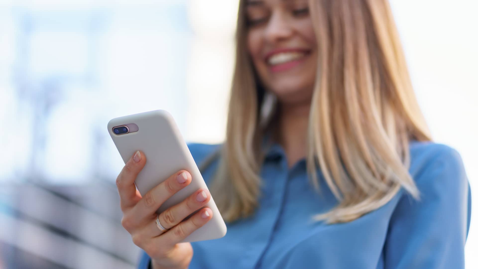 Mujer sonríe tras descubrir como activar el buzón de voz en su móvil de conttrato Digi Mobil