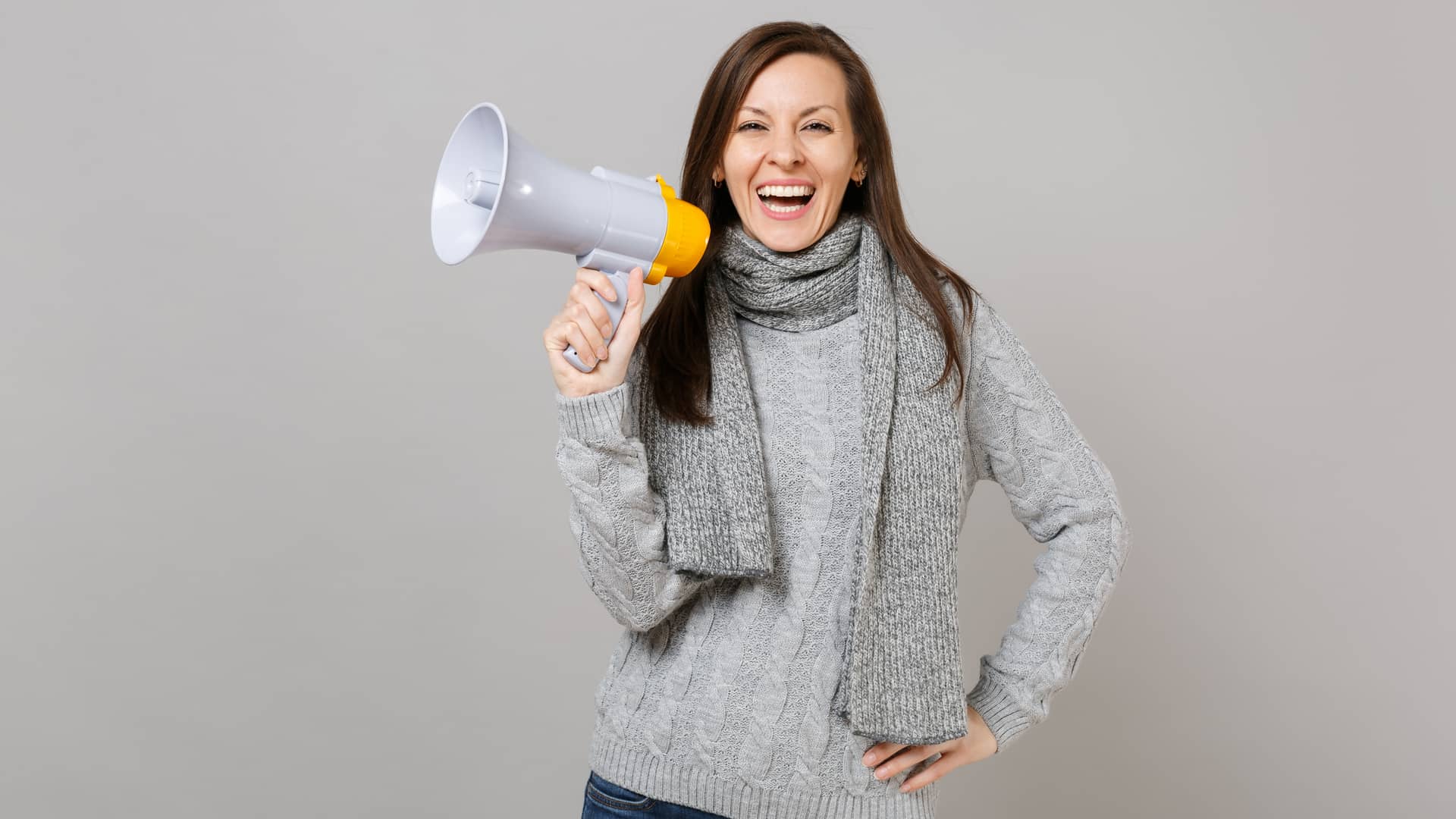 Mujer sostiene un megáfono mientras sonrie representando las opiniones de los usuarios de embou