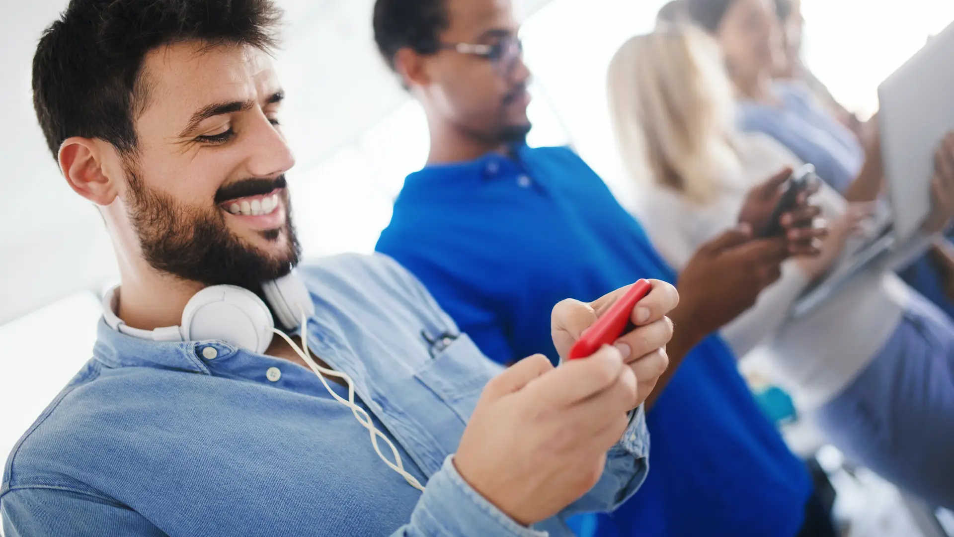 Joven de euskaltel compartiendo internet con su dispositivo a otros jóvenes Joven de euskaltel compartiendo internet con su dispositivo a otros jóvenes