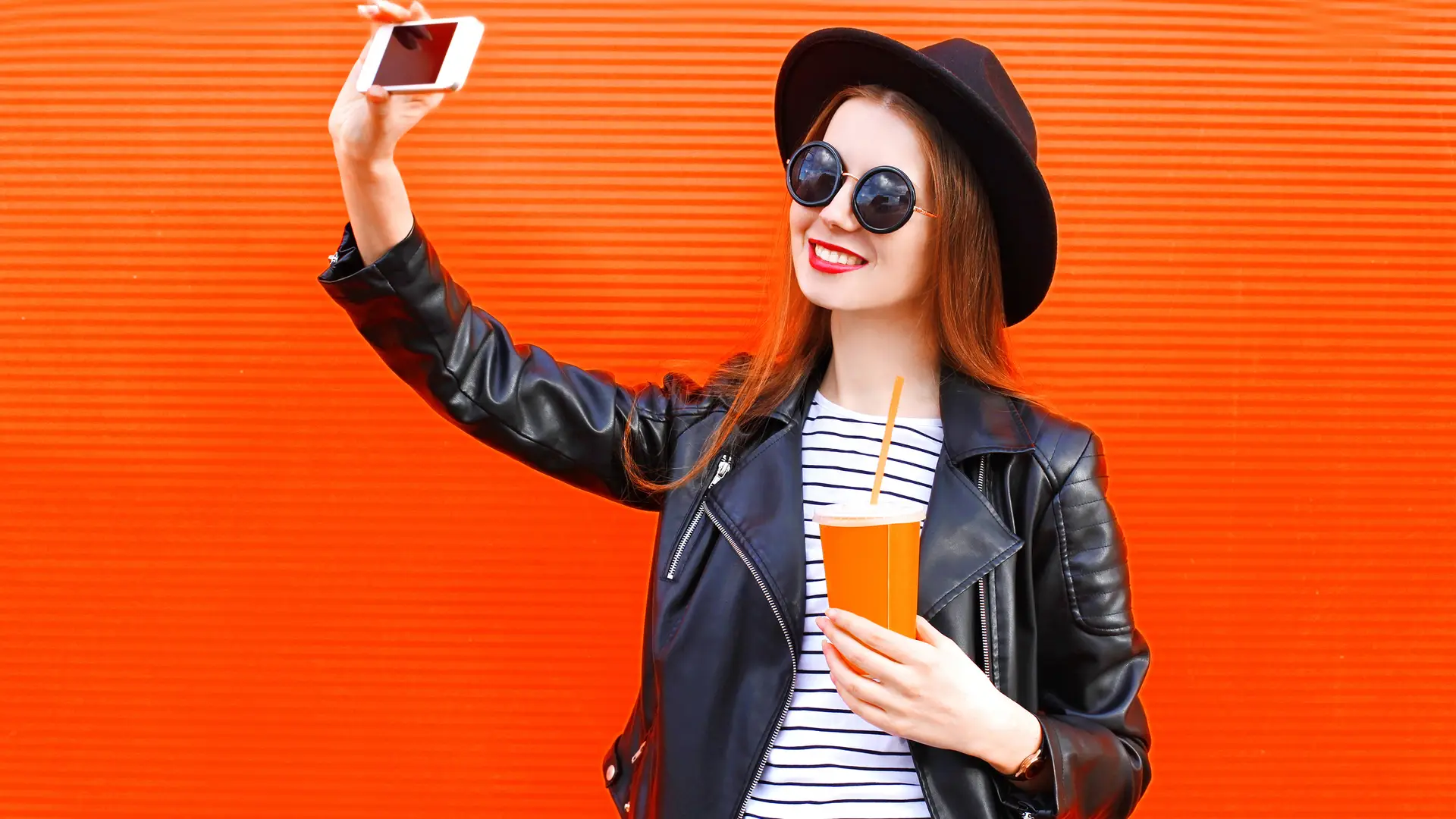 Joven haciendose un selfie con su bebida favorita simboliza móviles euskaltel Joven haciendose un selfie con su bebida favorita simboliza móviles euskaltel