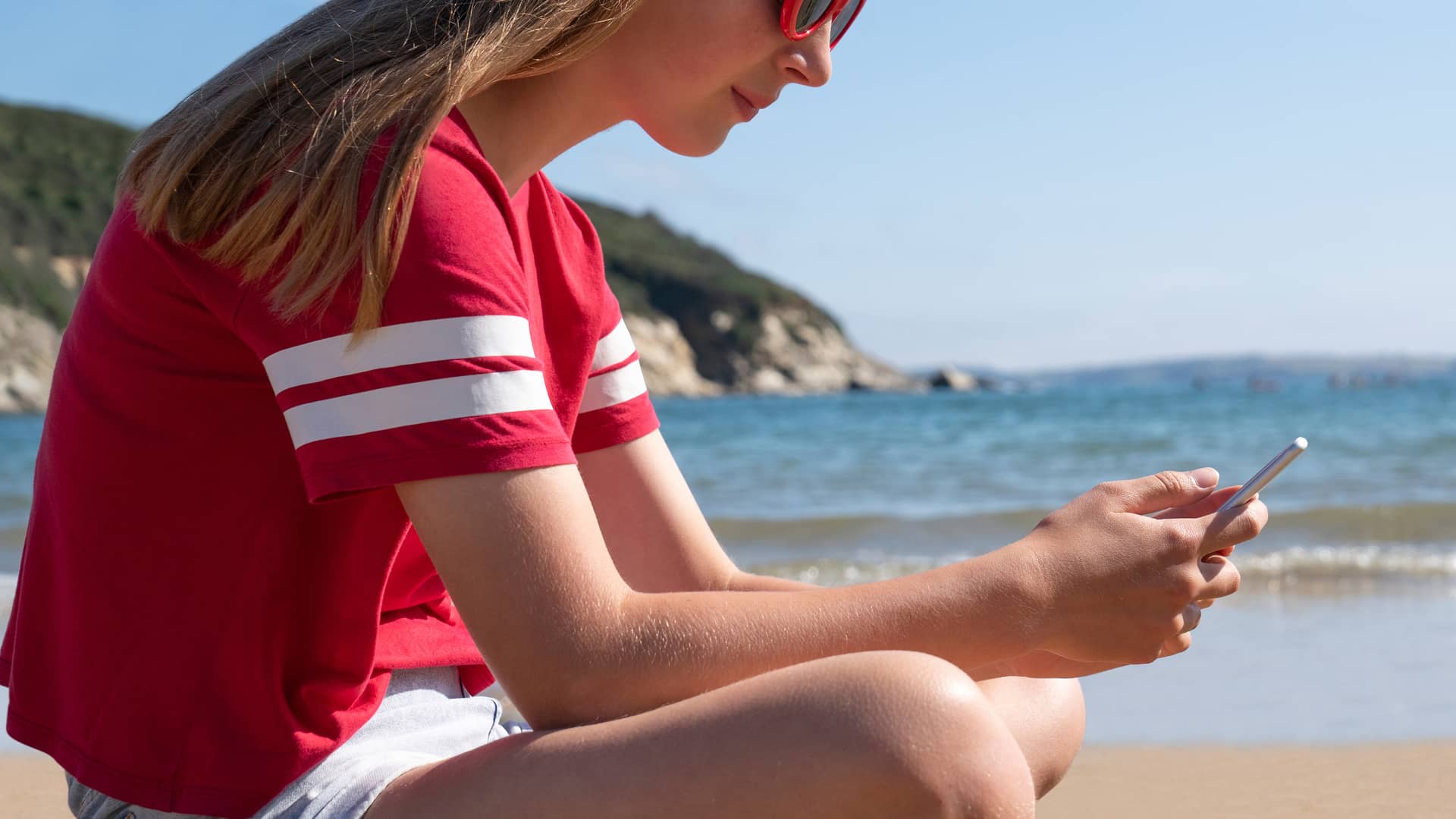 Adolescente en vacaciones navegando por internet con su smartphone gracias a wifi vacaciones de euskaltel