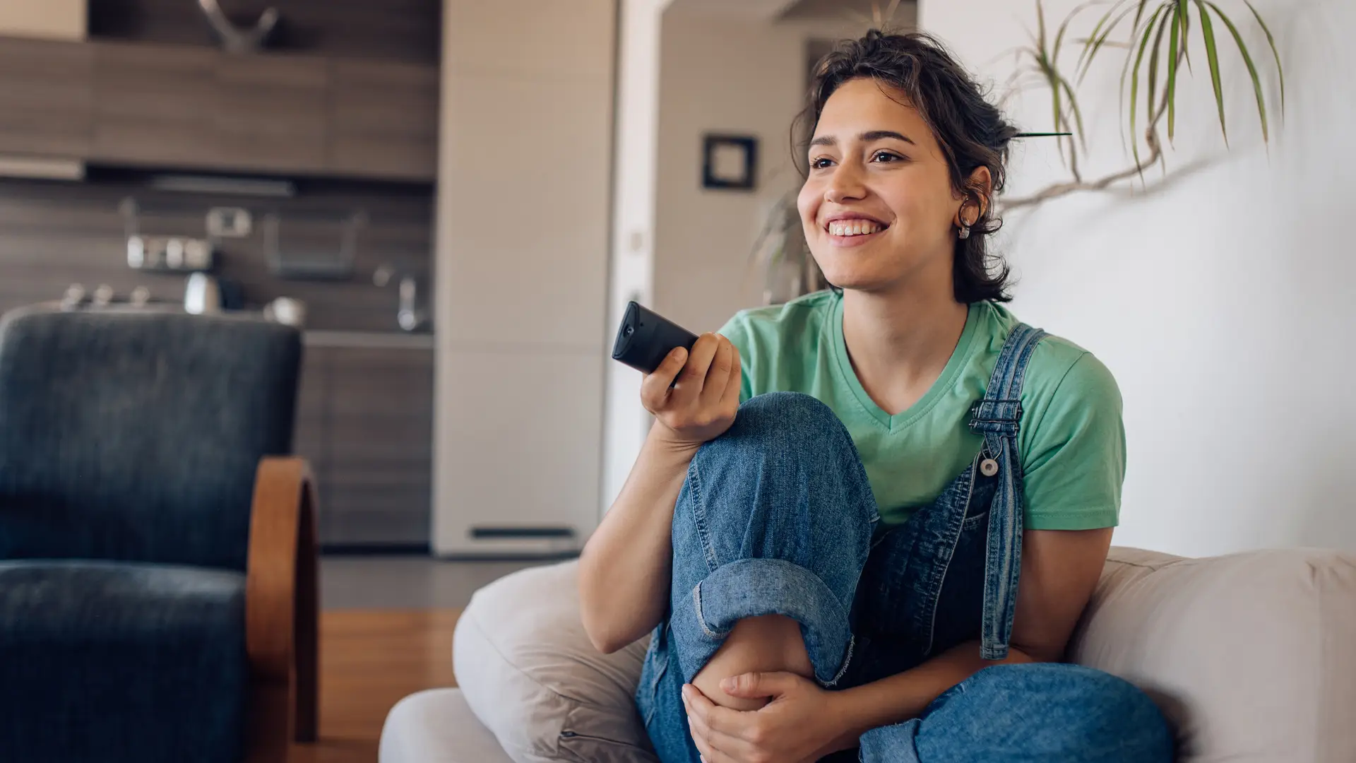 Chica disfrutando de su programa de televisión favorito en casa representa tarifas móvil internet y tv infinity