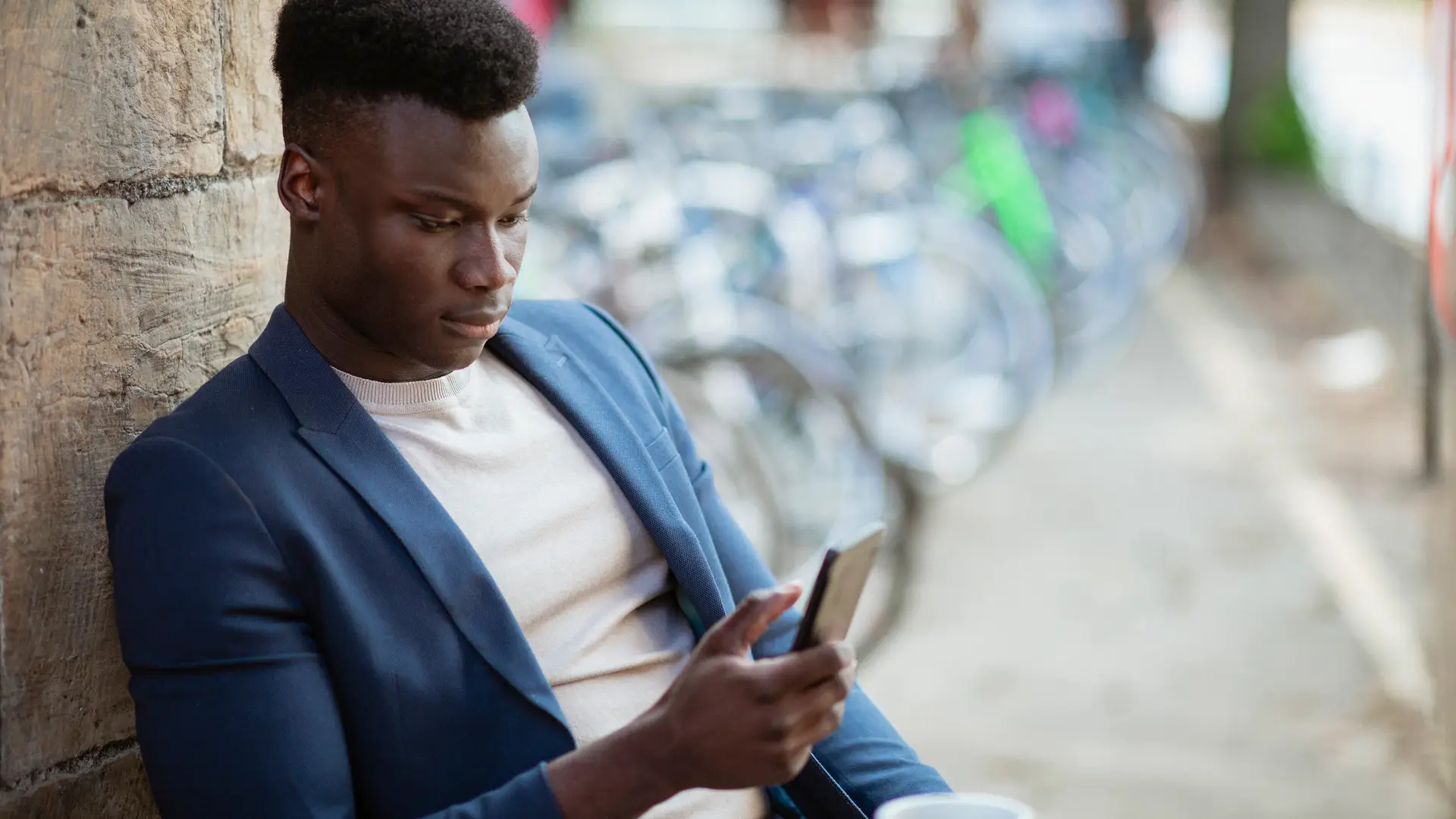 Joven con smartphone viendo las tarifas de móvil de finetwork Joven con smartphone viendo las tarifas de móvil de finetwork
