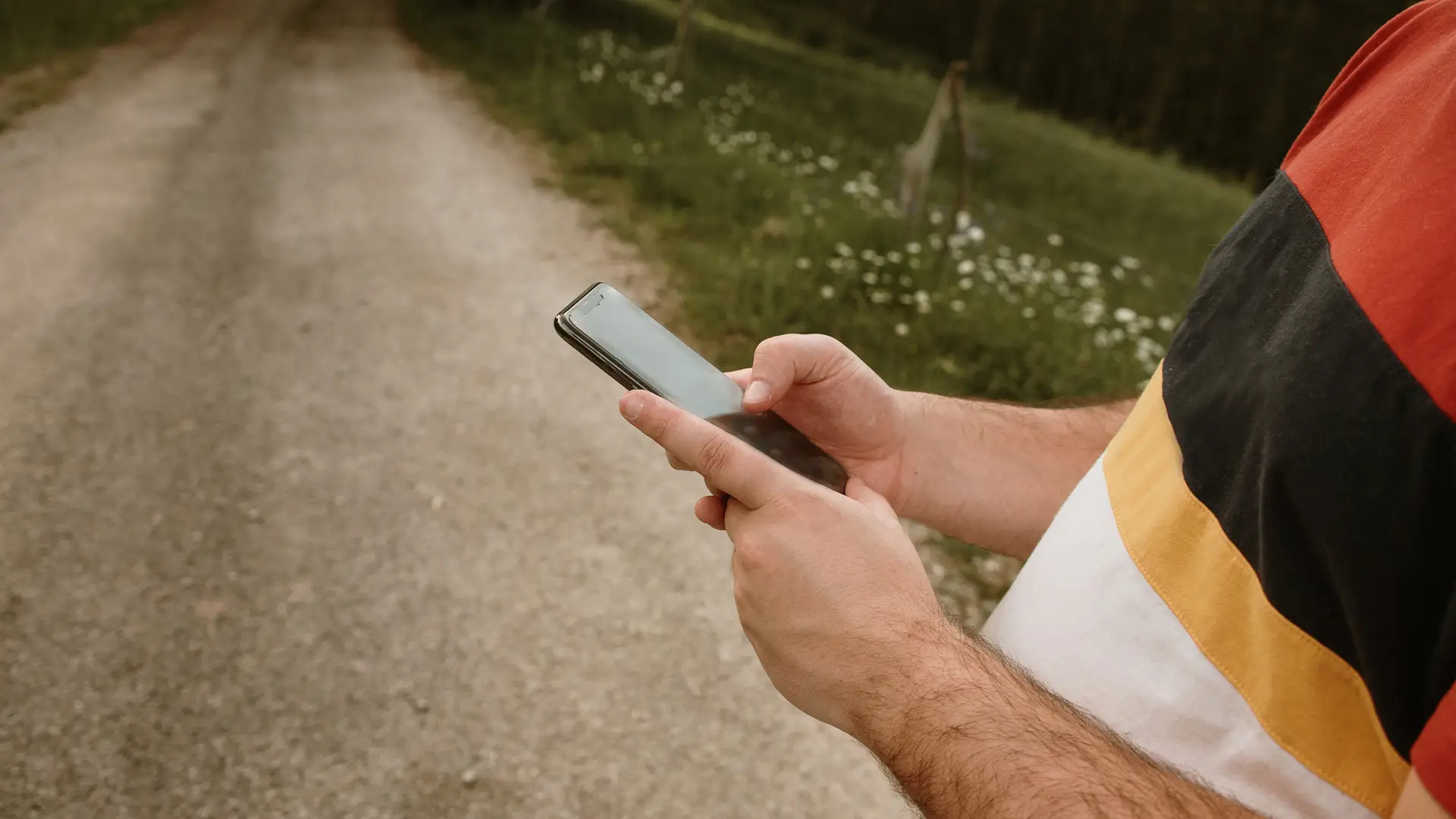 Hombre usando un teléfono inteligente para ver las tarifas de hitsmobile Hombre usando un teléfono inteligente para ver las tarifas de hitsmobile