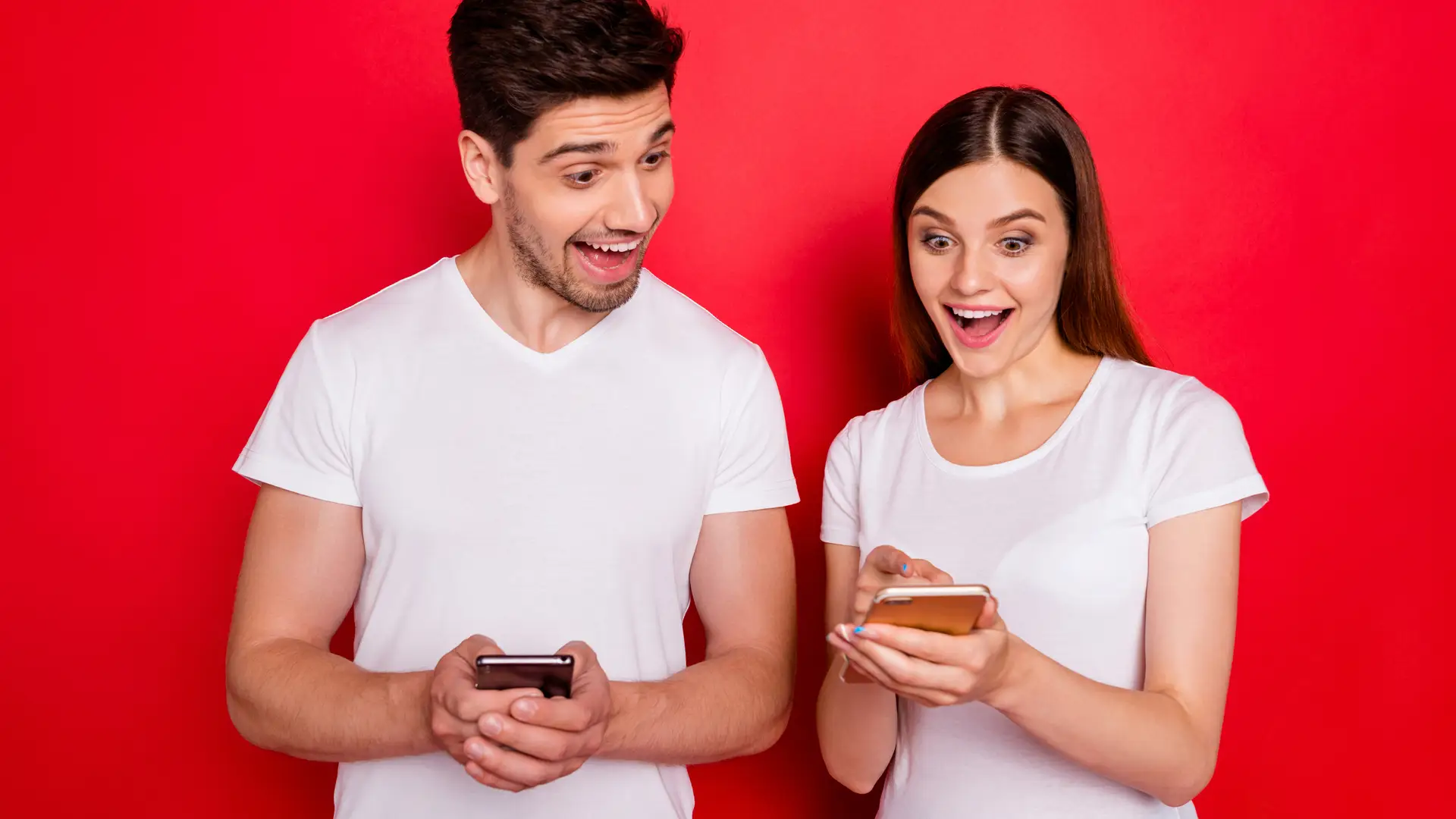 Pareja con sus smartphones felices representan móviles holafly