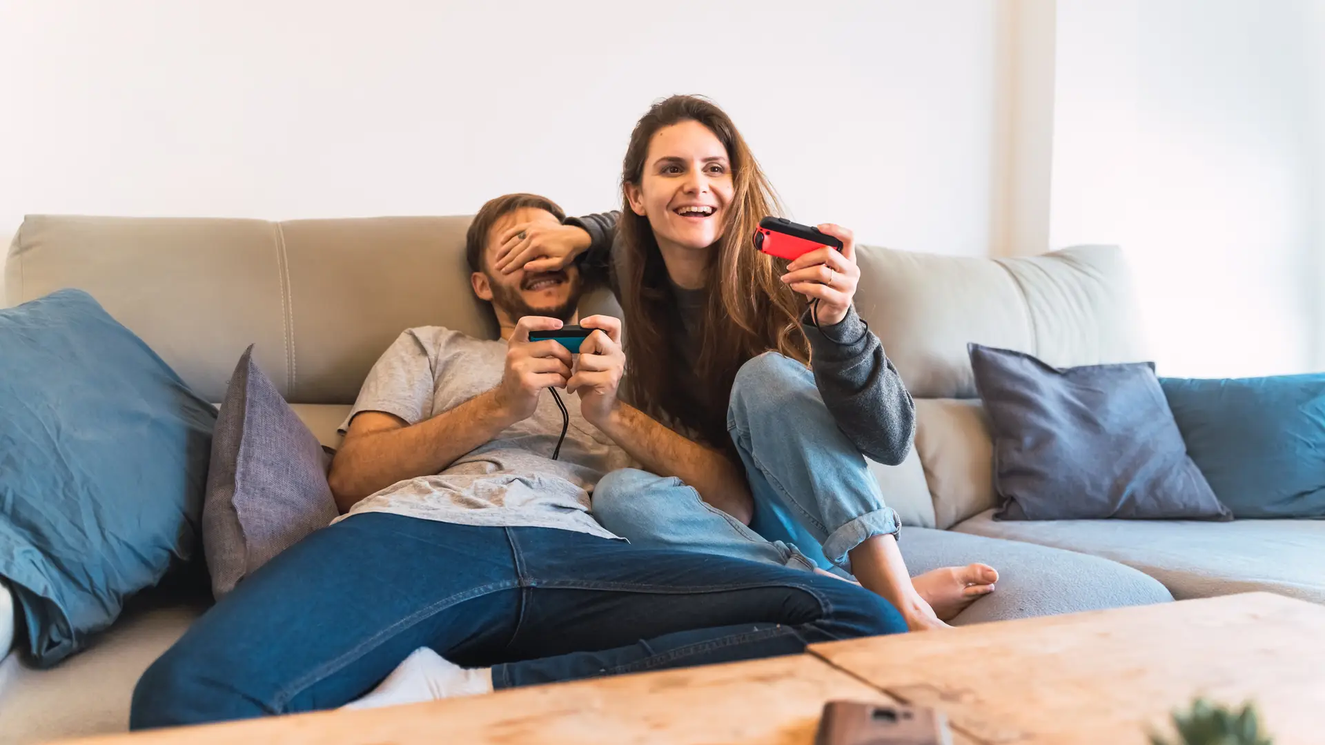 Mujer tapa los ojos de su novio mientras juegan a la nintendo switch, conseguida gracias a jazztel, para ganarle en competitivo Mujer tapa los ojos de su novio mientras juegan a la nintendo switch, conseguida gracias a jazztel, para ganarle en competitivo
