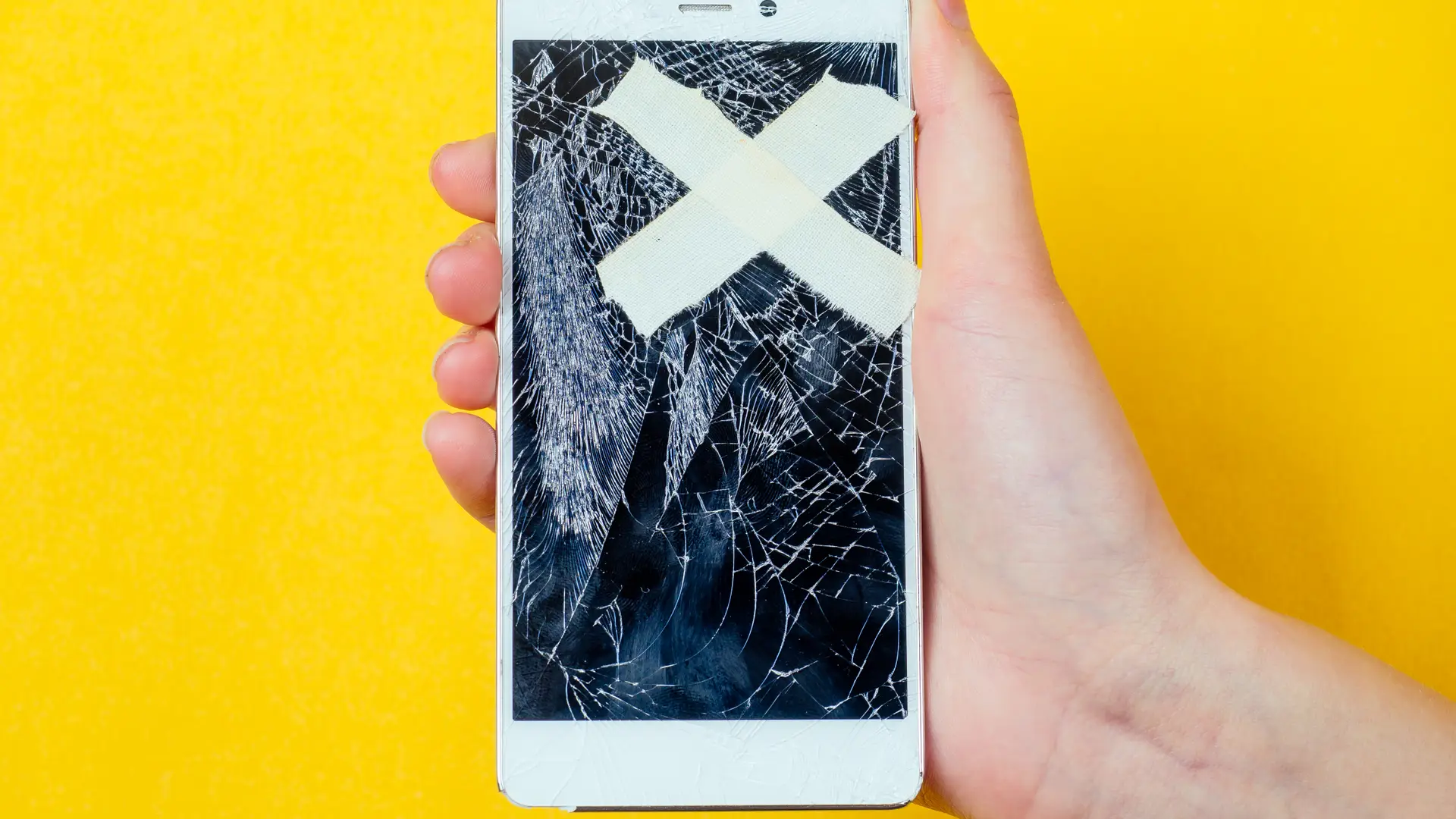 Smartphone con la pantalla rota y una X pegada por encima a modo de tiritas, el dueño debería haberse suscrito al seguro móvil de jazztel Smartphone con la pantalla rota y una X pegada por encima a modo de tiritas, el dueño debería haberse suscrito al seguro móvil de jazztel