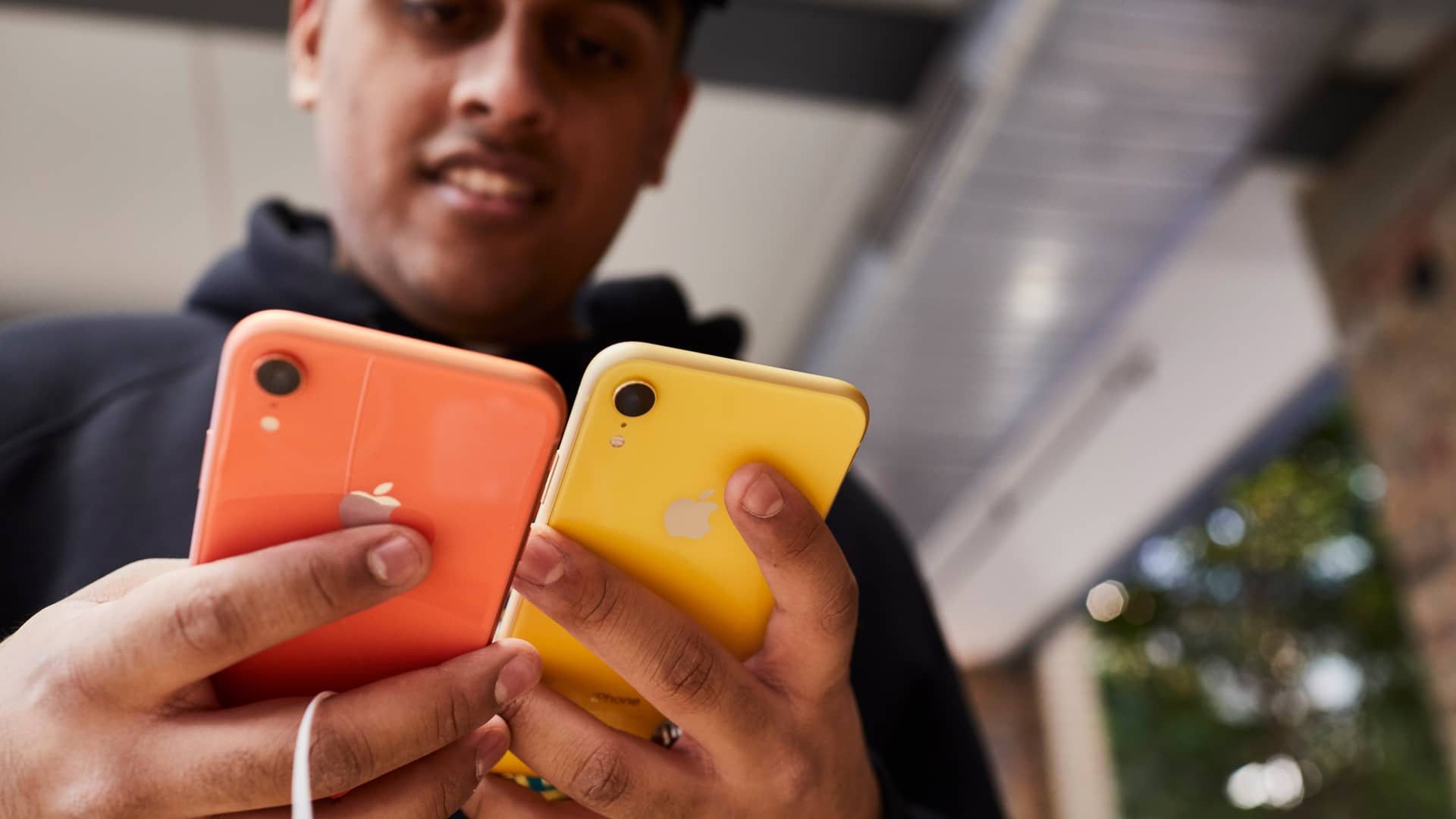 Hombre interesado en el iphone XR elige entre dos colores distintos