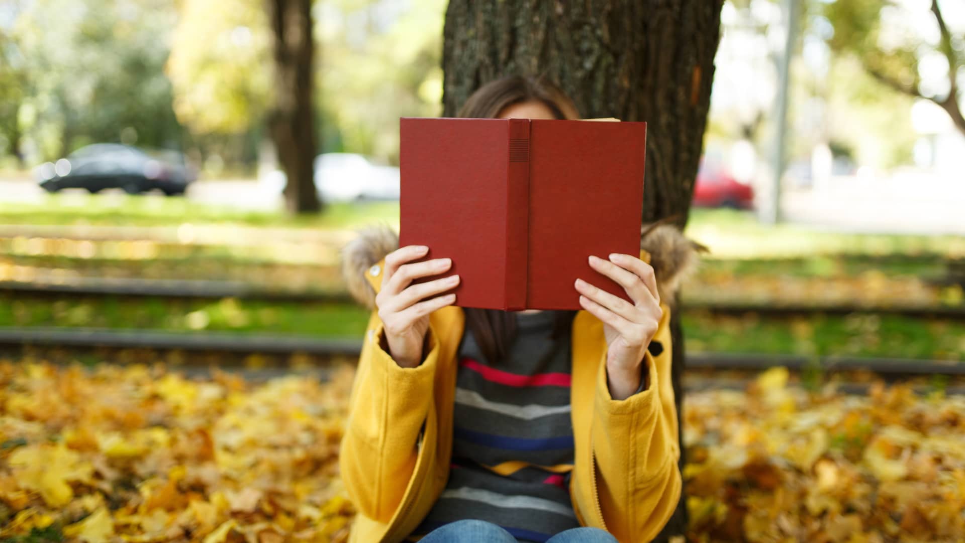 Mujer ocultando su rostro tras un libro simboliza la posibilidad de ocultar tu número en tu móvil y fijo con jazztel