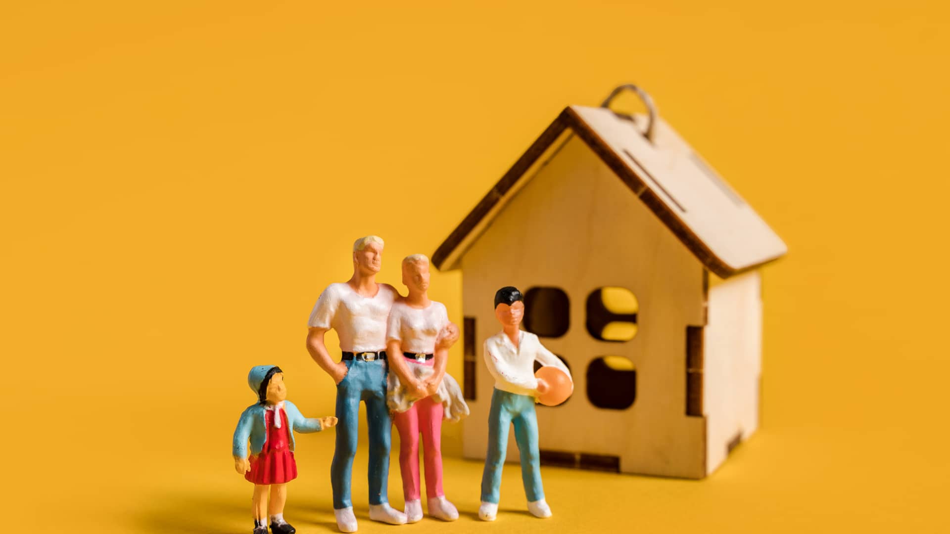 Figuritas de una familia junto con una casa de juguete para hablar de cómo tramitar un cambio de domicilio con jazztel