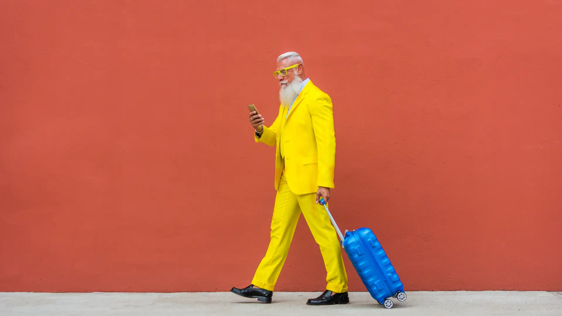 Hombre mayor con traje y gafas amarillas, lleva una maleta y un móvil, simulando su portabilidad a Jazztel Hombre mayor con traje y gafas amarillas, lleva una maleta y un móvil, simulando su portabilidad a Jazztel