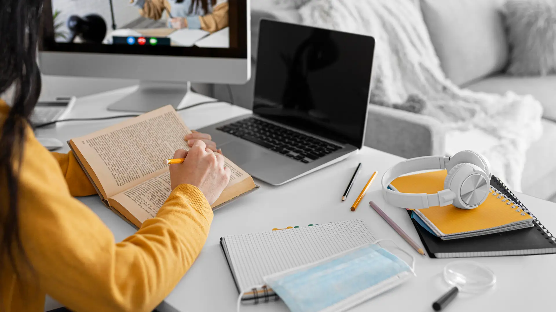 Estudiante ve una clase online en su sobremesa gracias a su tarifa jazztel mientras consulta detalles de un libro Estudiante ve una clase online en su sobremesa gracias a su tarifa jazztel mientras consulta detalles de un libro