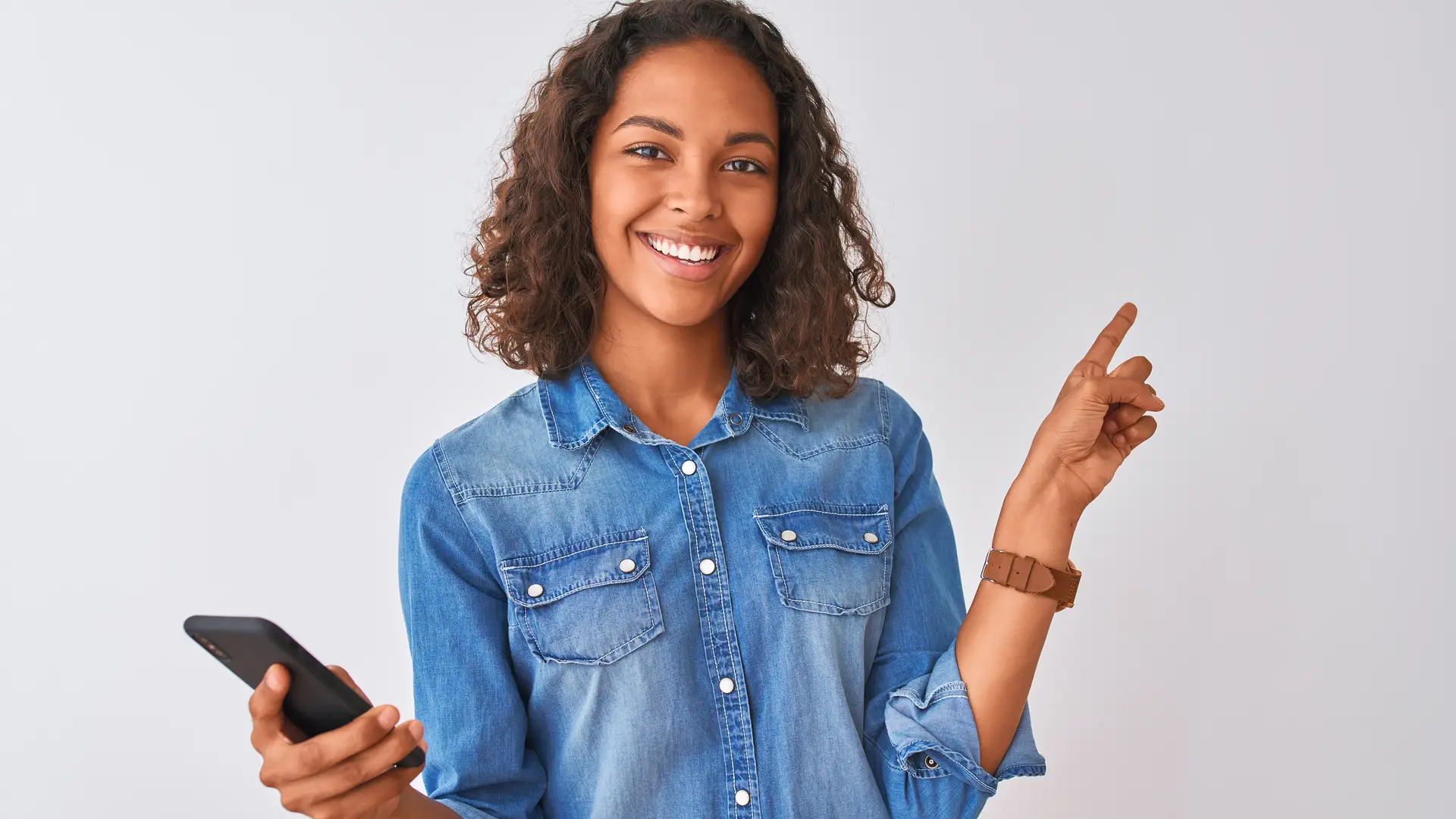 Joven sonriente con su smartphone consultando sus megas en lebara Joven sonriente con su smartphone consultando sus megas en lebara