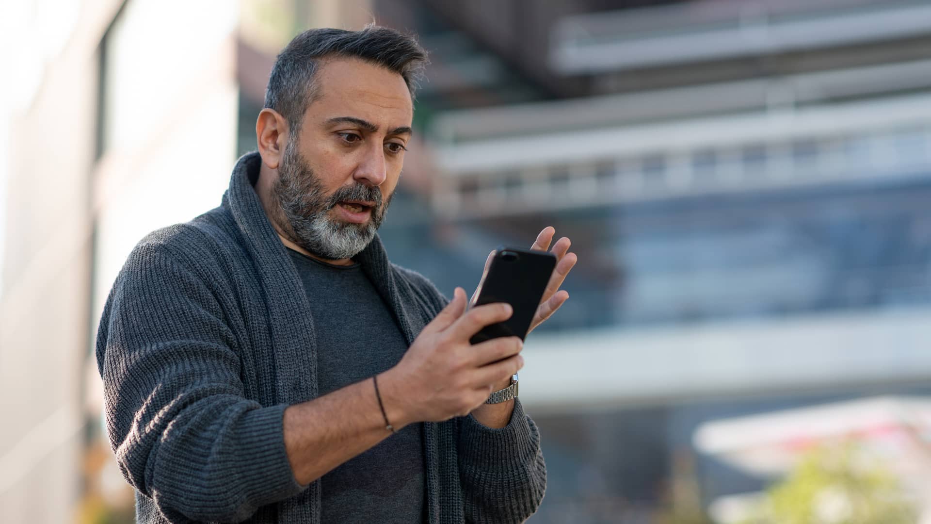 Hombre sorprendido viendo en su smartphone las tarifas móvil e internet de lemmon